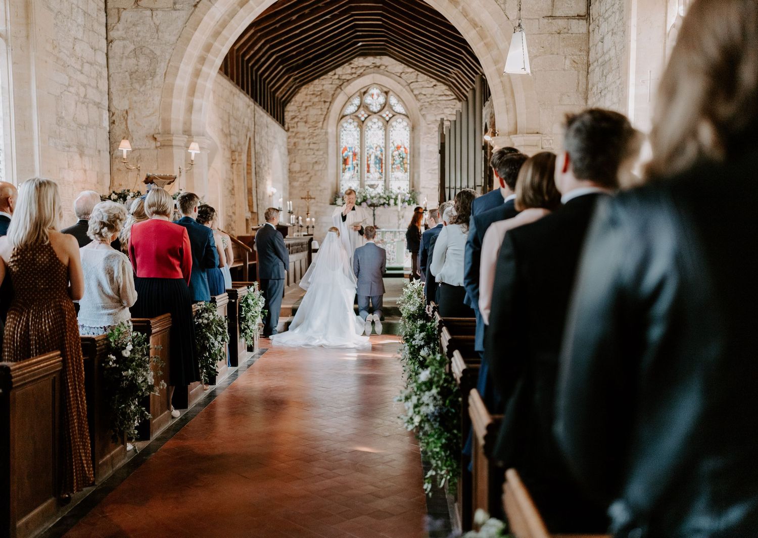 Wedding ceremony in a historic stone church with elegant decorations.
