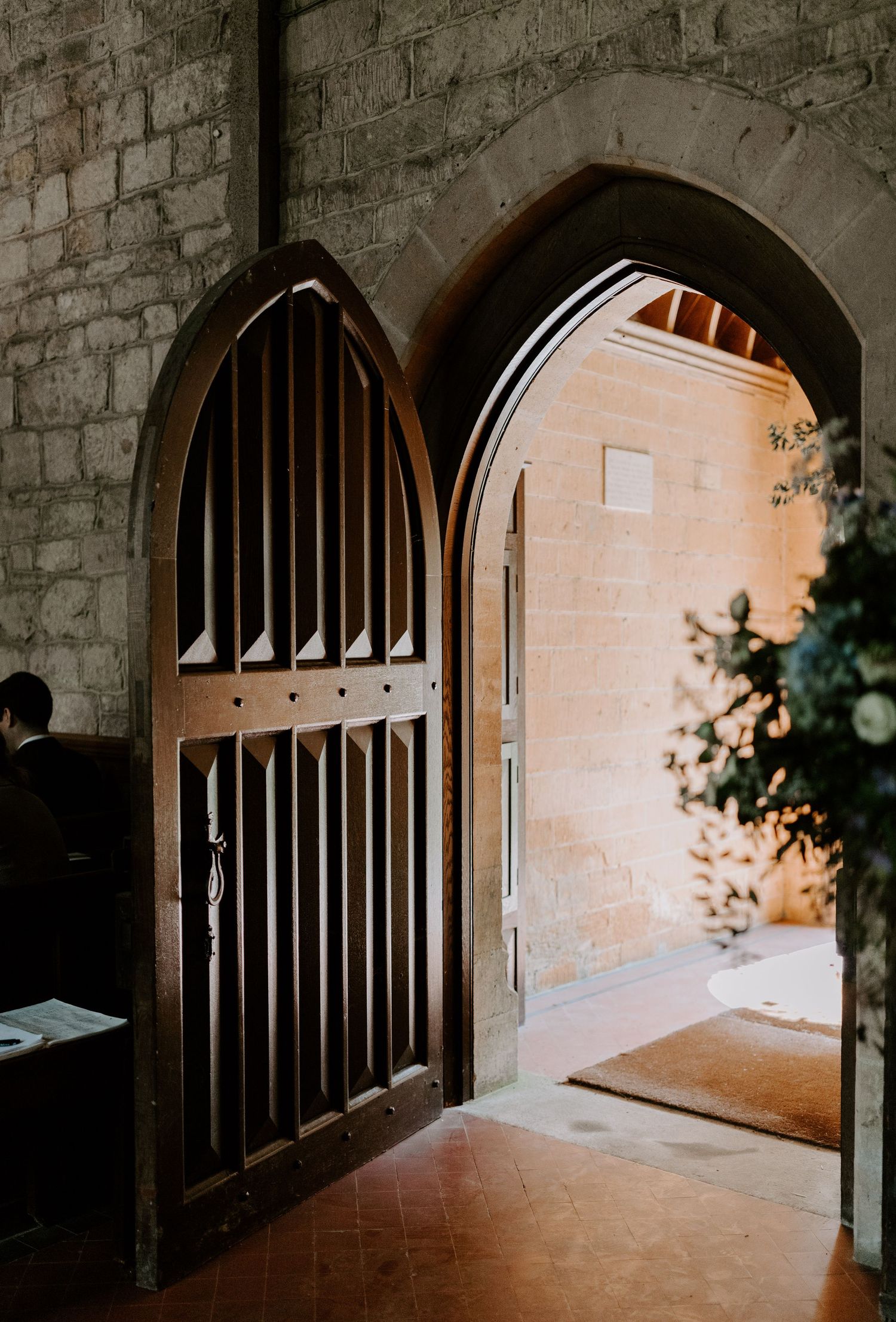 Stone archways in a historic building create a dramatic corridor with natural lighting.