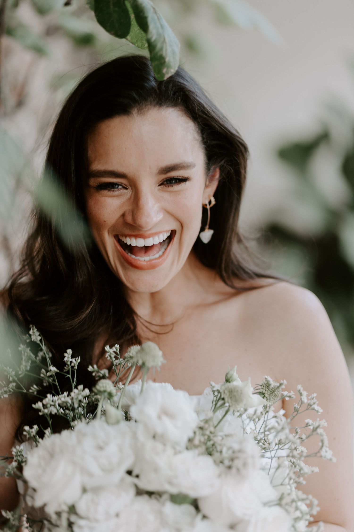Joyful bridal portrait with white floral bouquet and baby's breath details.