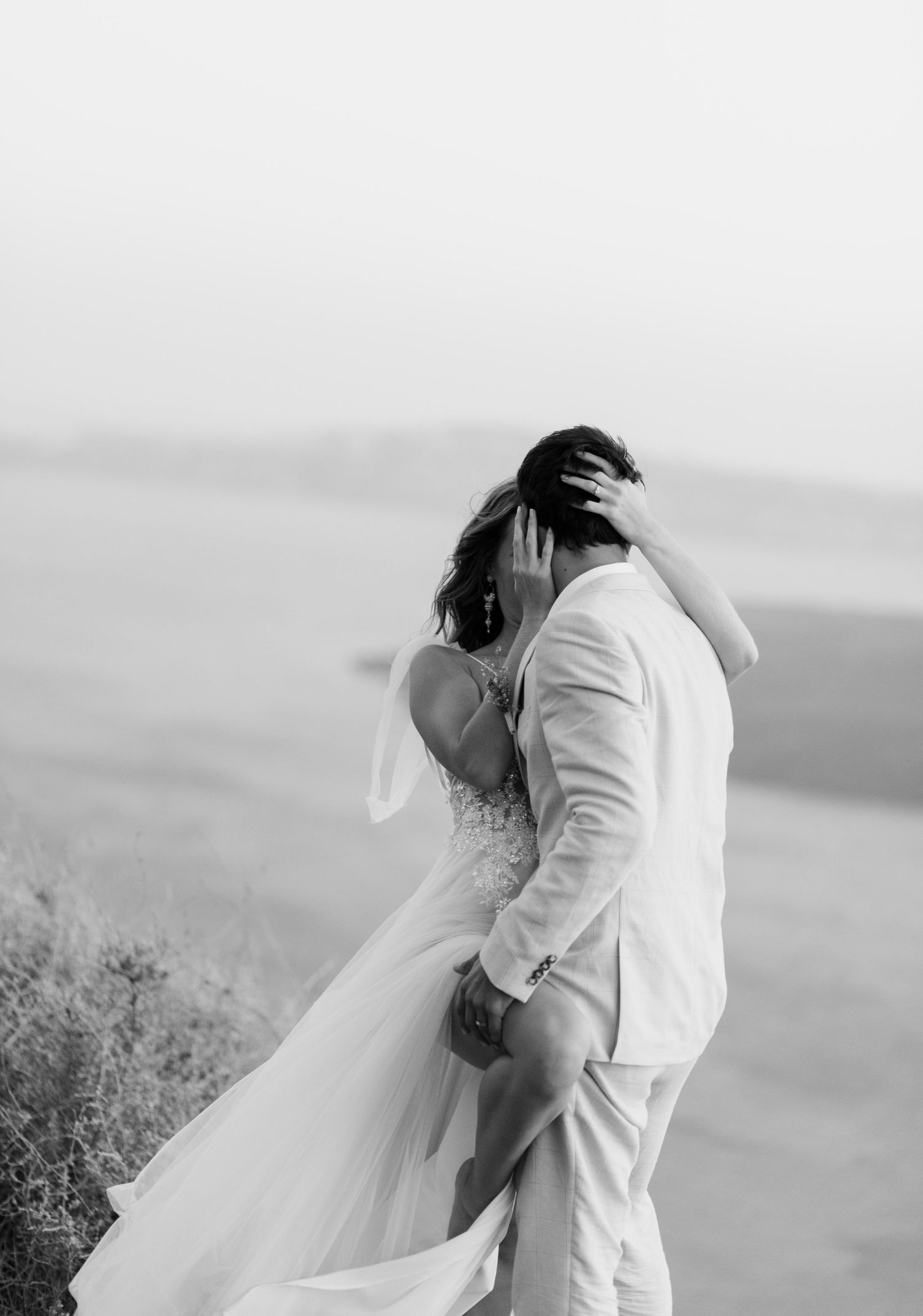 Intimate black and white wedding moment captured against a scenic coastal backdrop in Santorini.