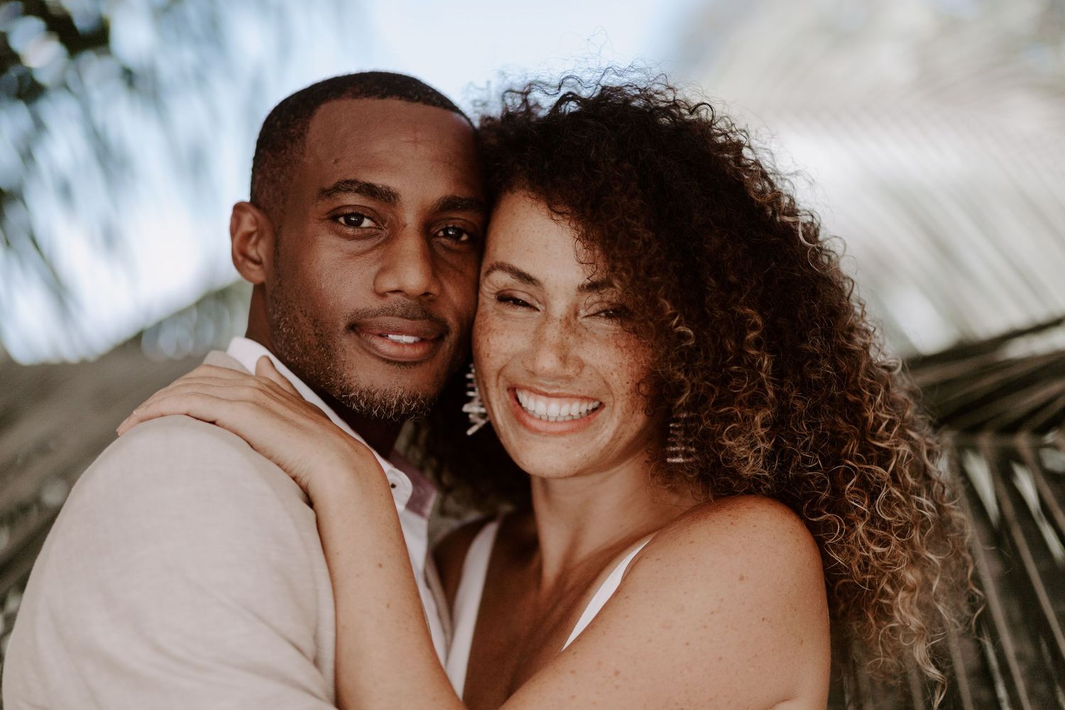 A couple shares a joyful moment together in natural lighting.