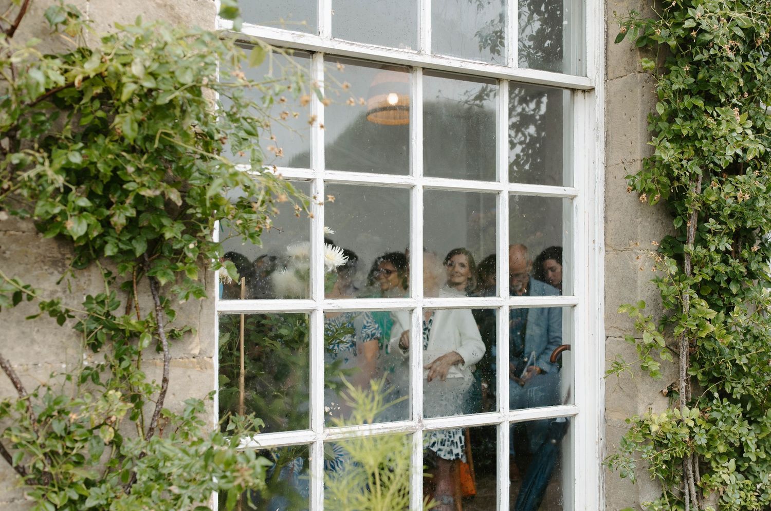 A rustic window exterior with climbing vines during the ceremony