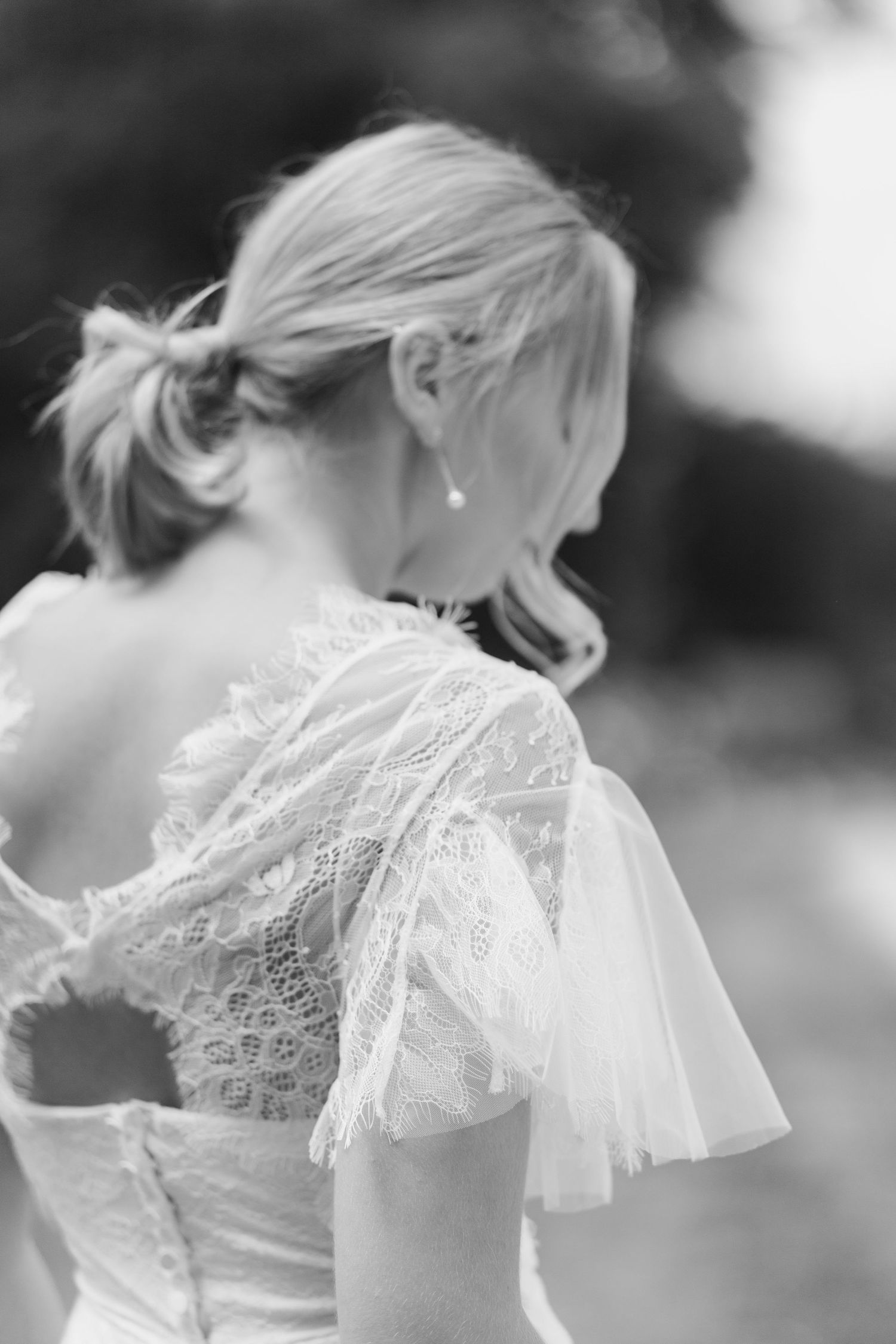 Close-up details of delicate lace trim and ruffles on a white wedding dress sleeve.