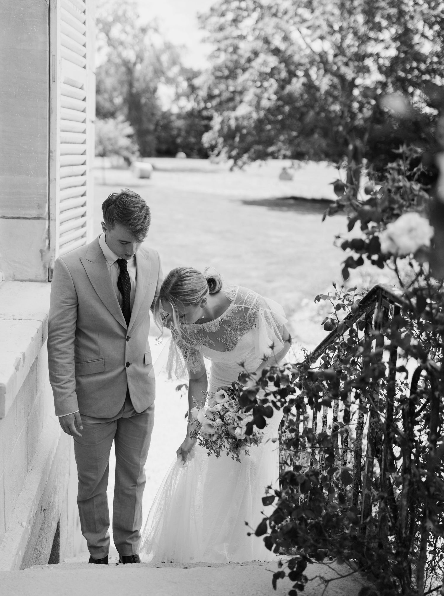 Black and white wedding photos captured on outdoor steps with romantic poses.