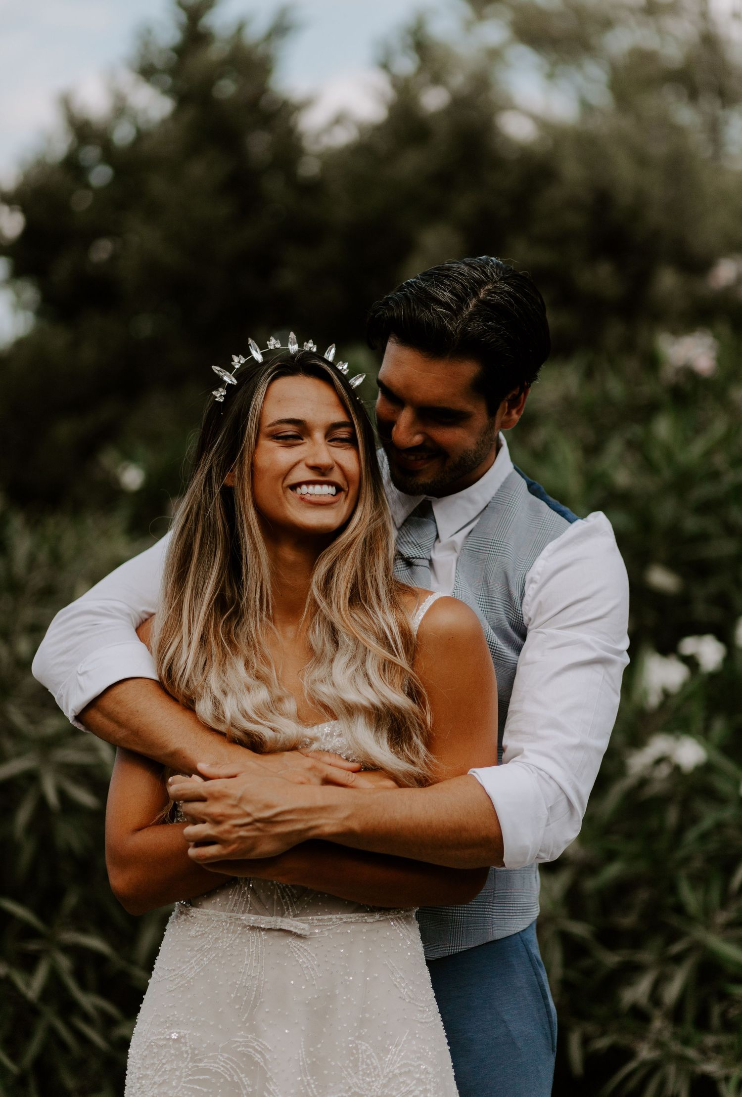 Joyful couple embracing and laughing together during outdoor photo session.