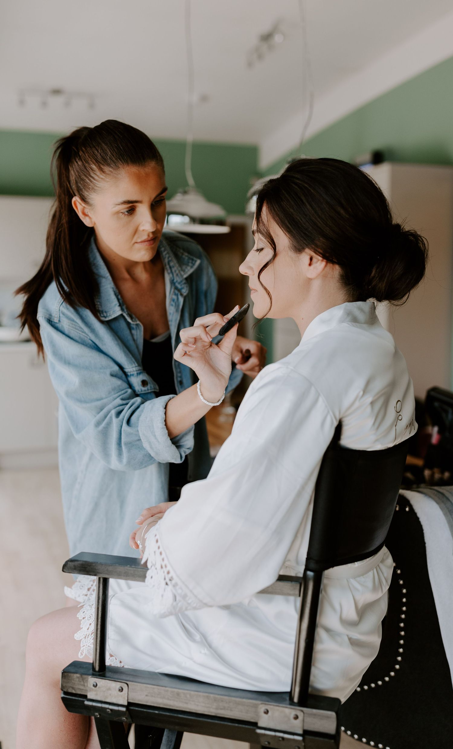 Professional makeup application session in a bright modern studio setting.