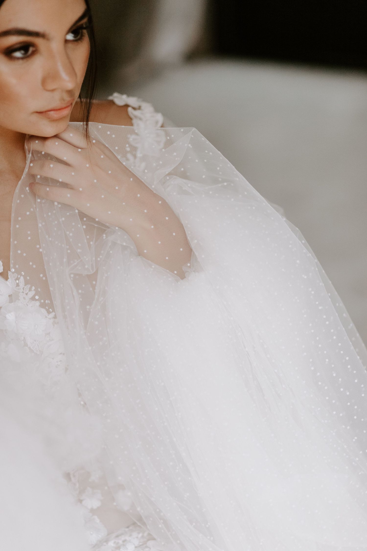 Dreamy close-up of sparkling tulle and delicate bridal details in soft lighting.