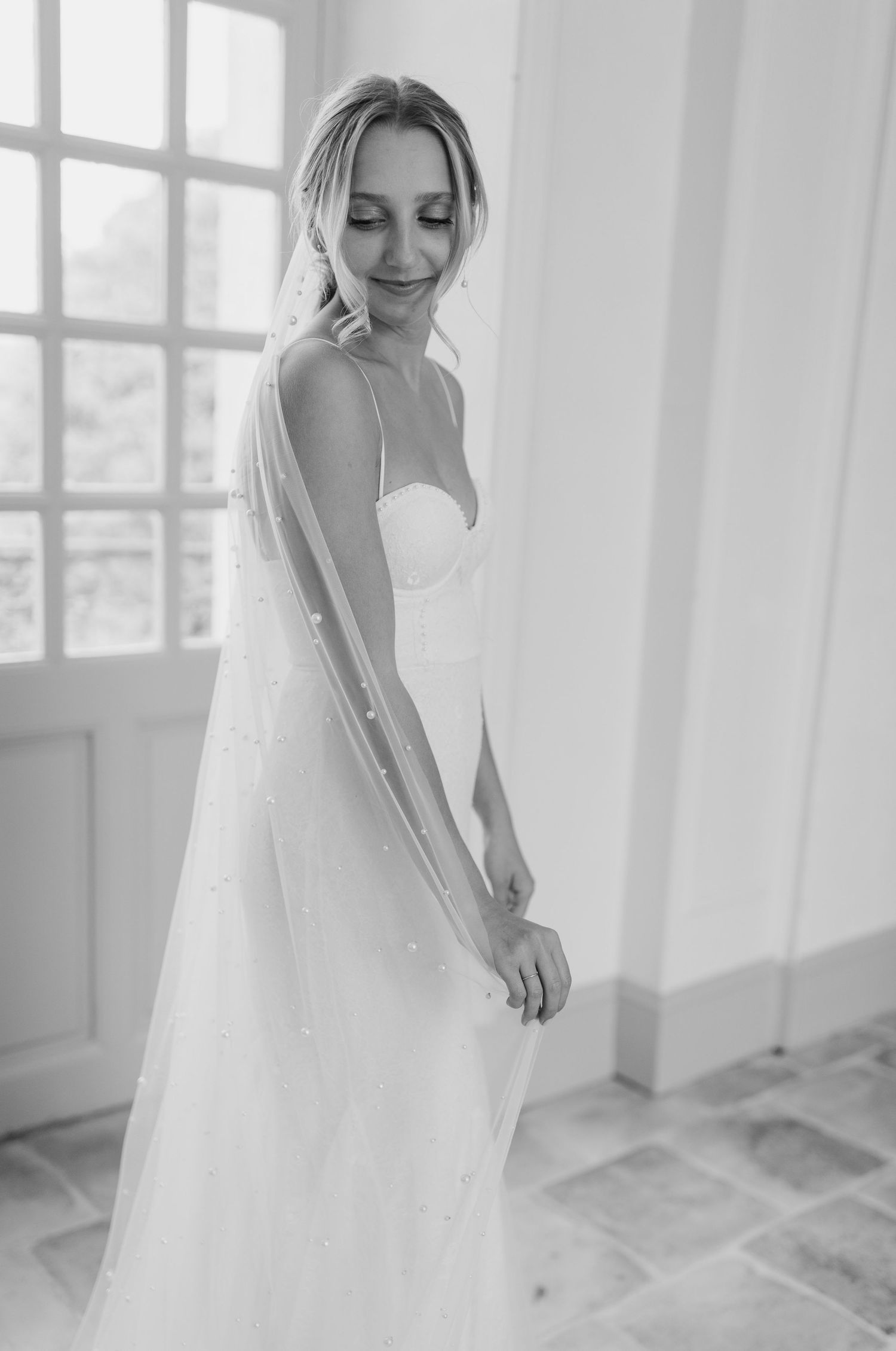 Ethereal bridal portrait in a bright white room with large windows.