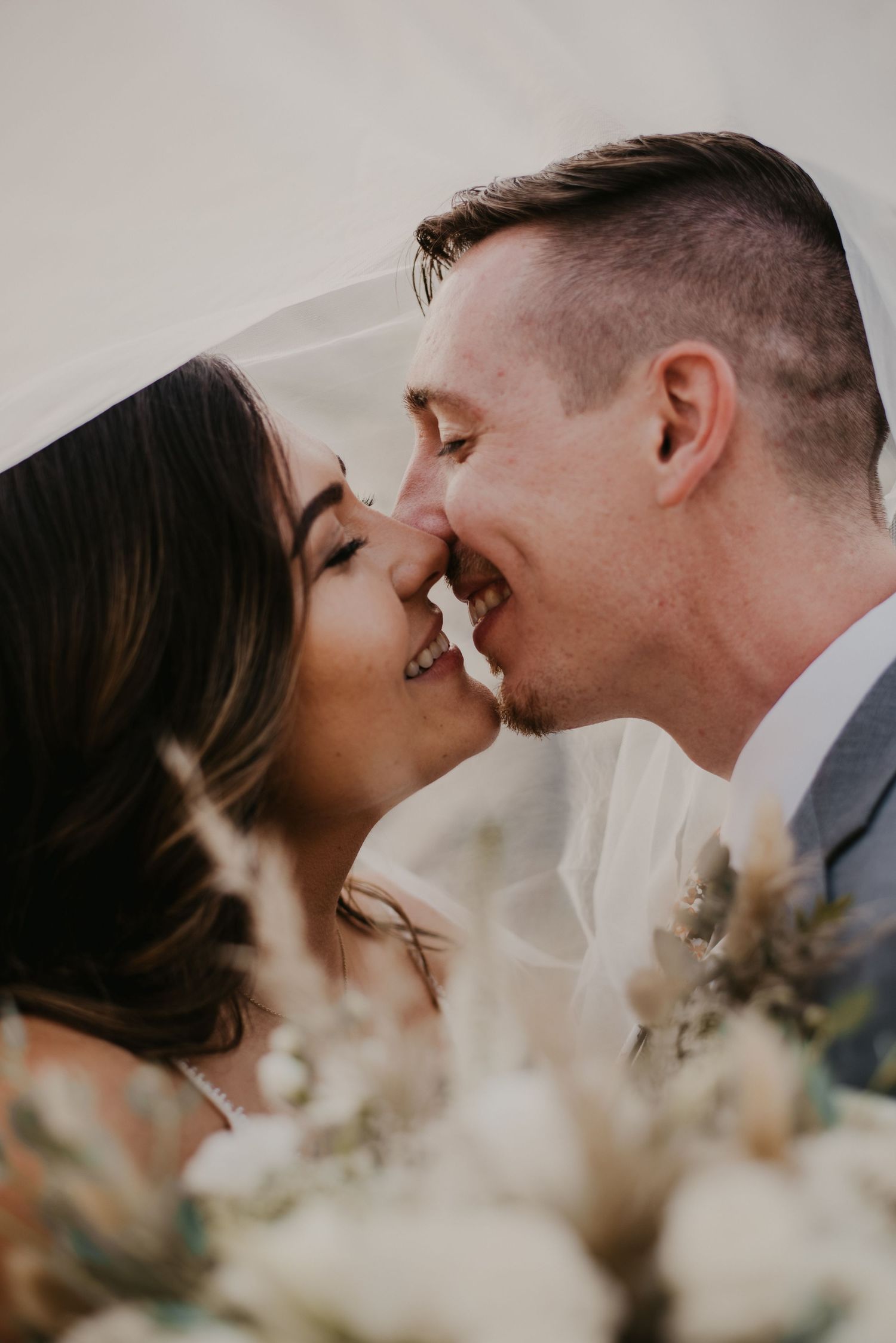 Romantic wedding moment of a bride and groom kissing, captured by Willow + Vine Photography in a natural, candid style.