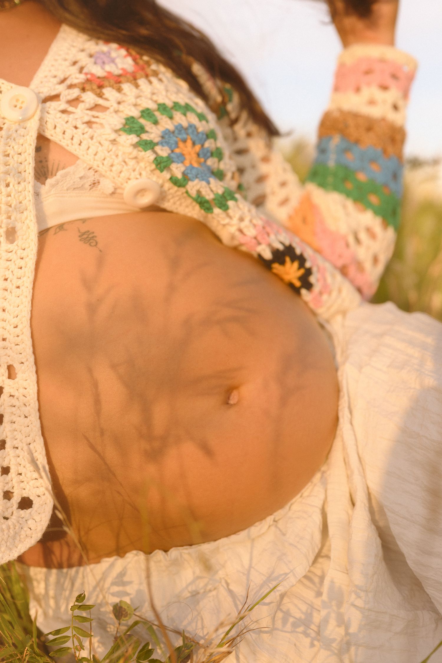 Artistic close-up of handcrafted crochet garment with colorful floral patterns.