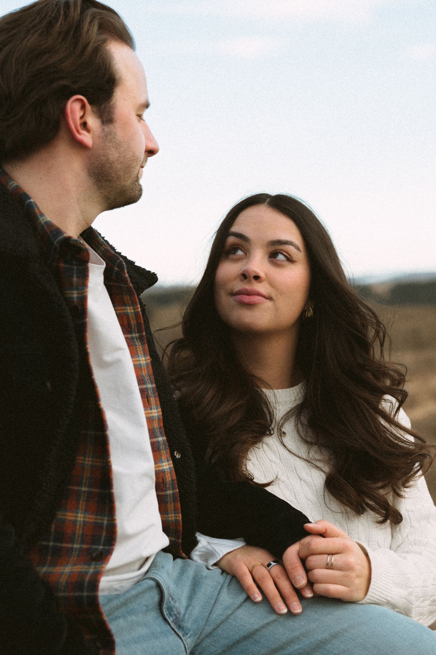 A couple shares intimate moments together outdoors, shown in a series of candid romantic poses.