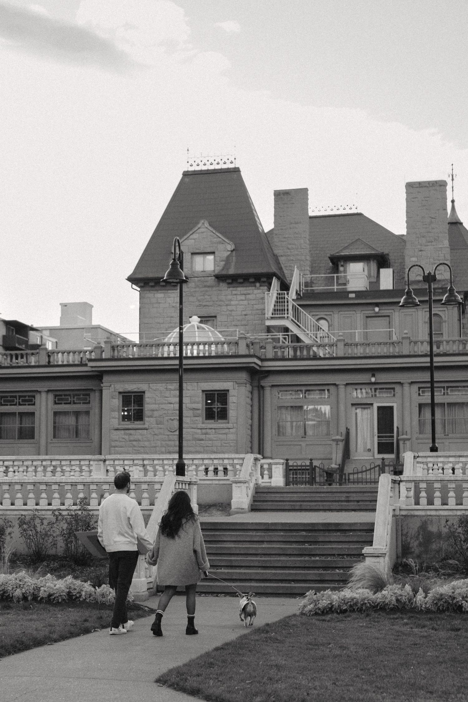 A black and white photo series showing people walking on steps near a historic mansion building with ornate balustrades.