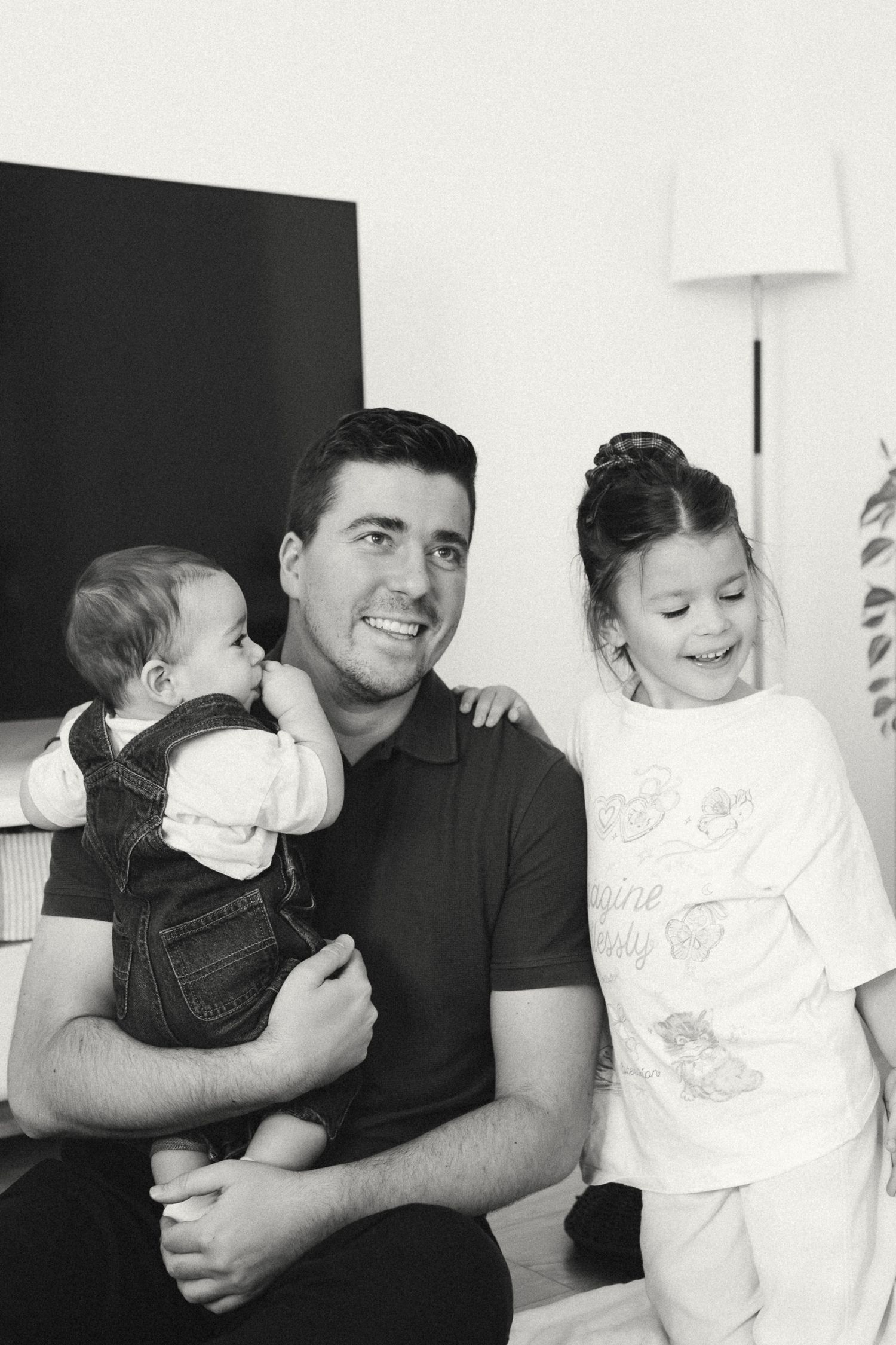 A series of black and white family photos showing tender moments between a parent and children.