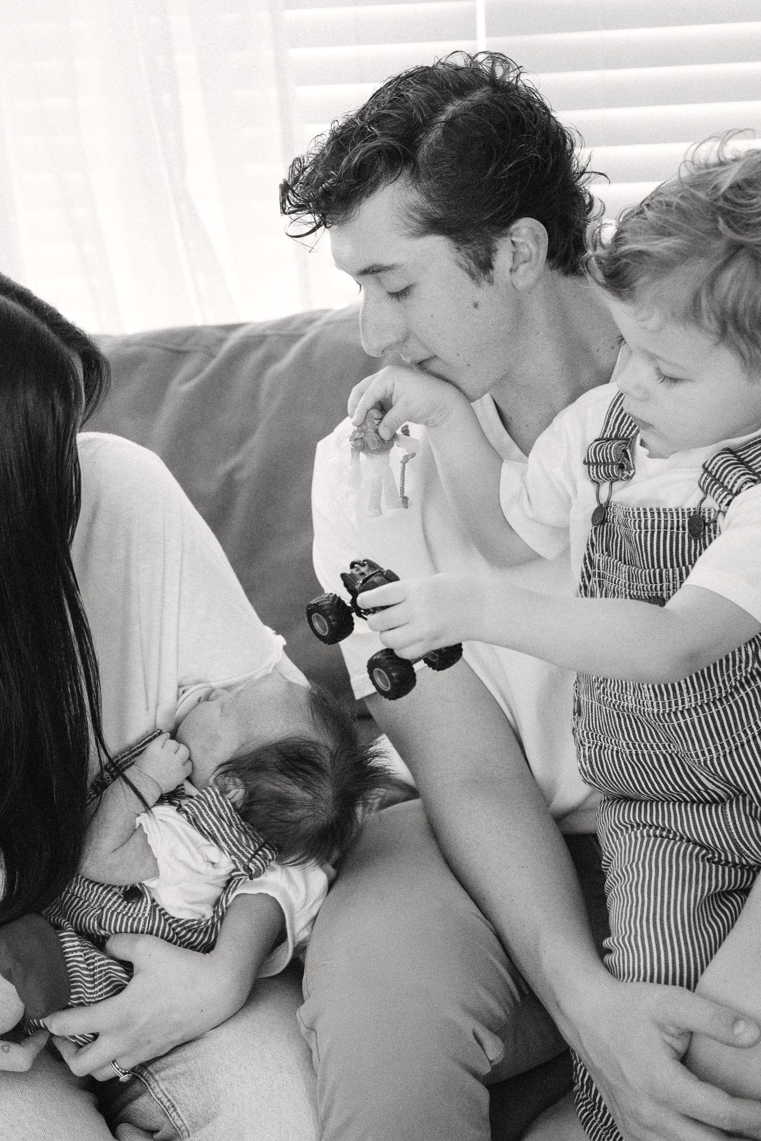 Black and white photos capturing intimate family moments on a couch near a window.