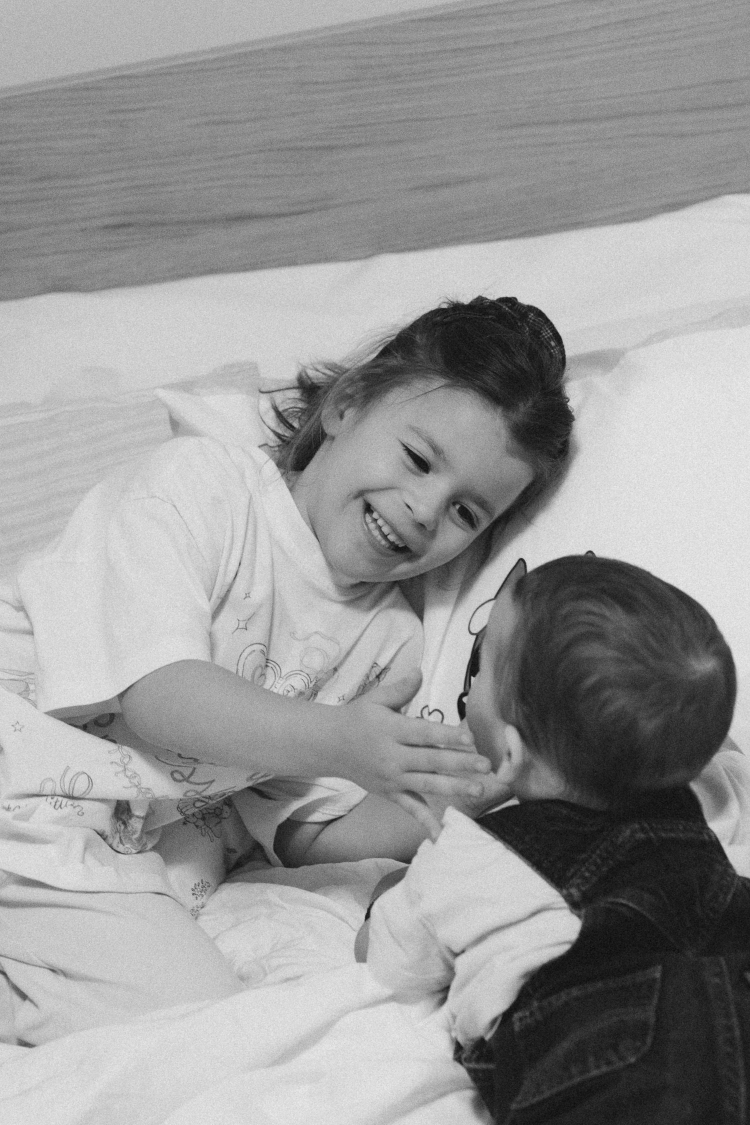 A black and white sequence showing two people playfully interacting on a bed.