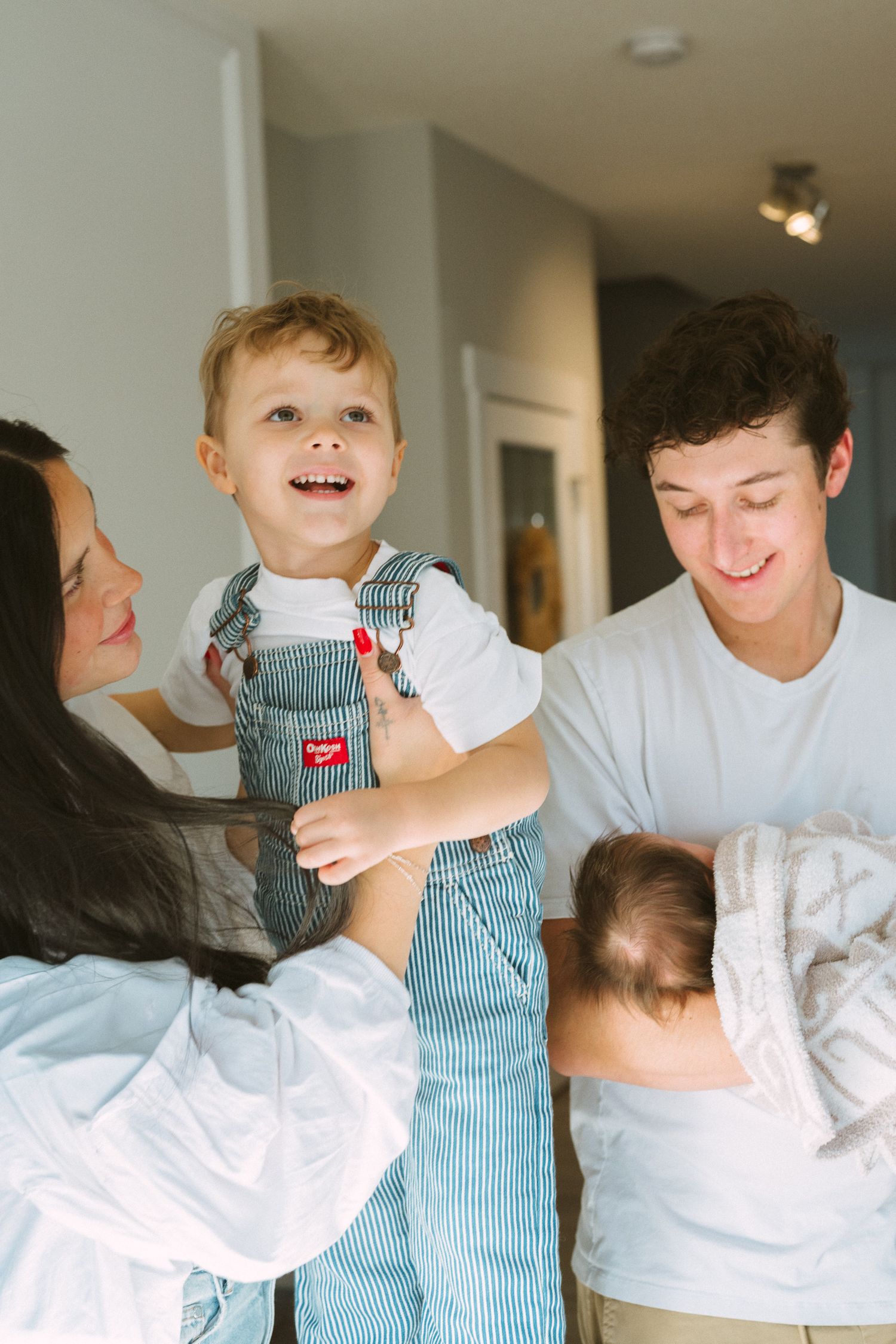 Candid moments of family playtime captured in sequence against a white wall background.