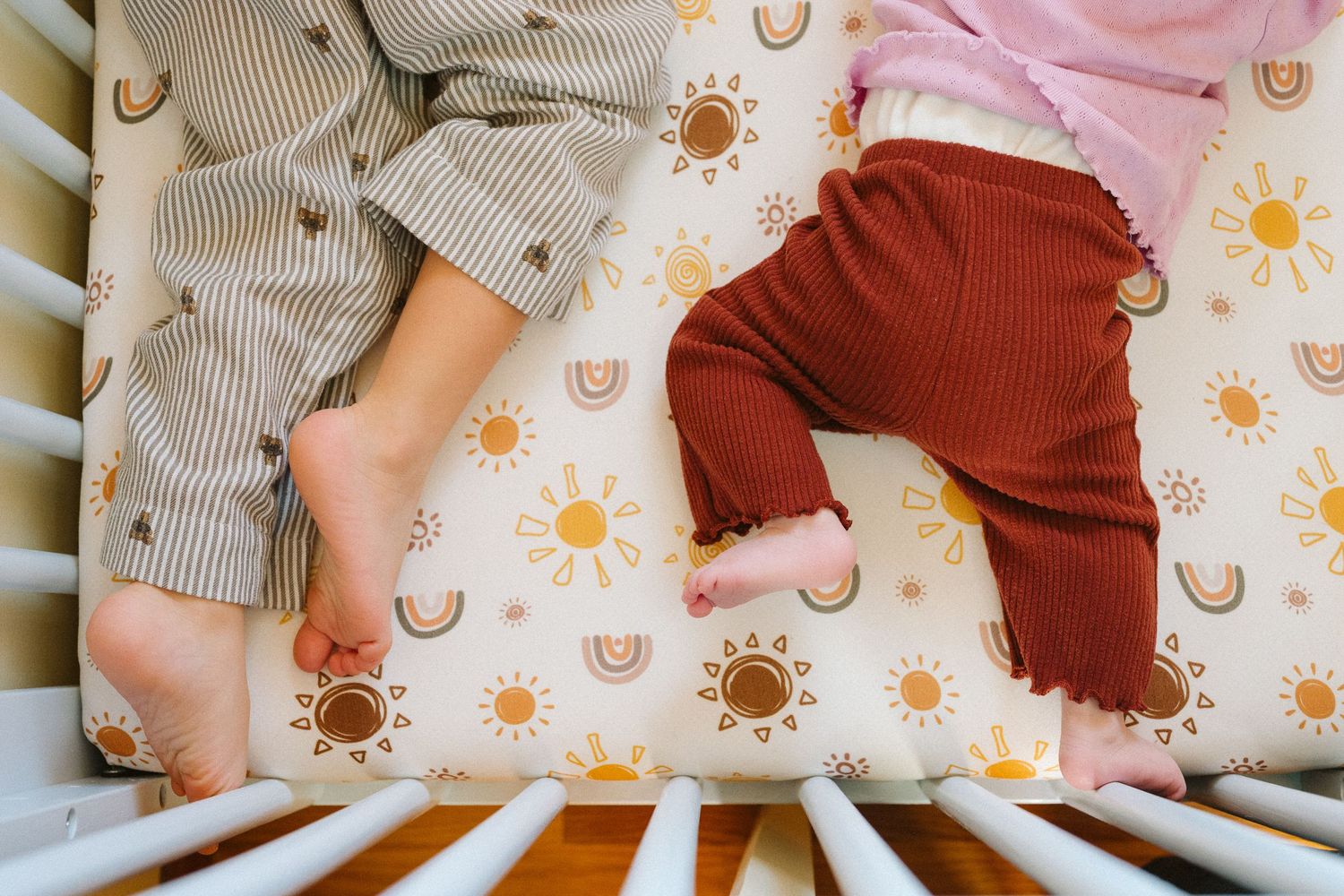 Cozy nursery scene with striped clothing and sun pattern decor.