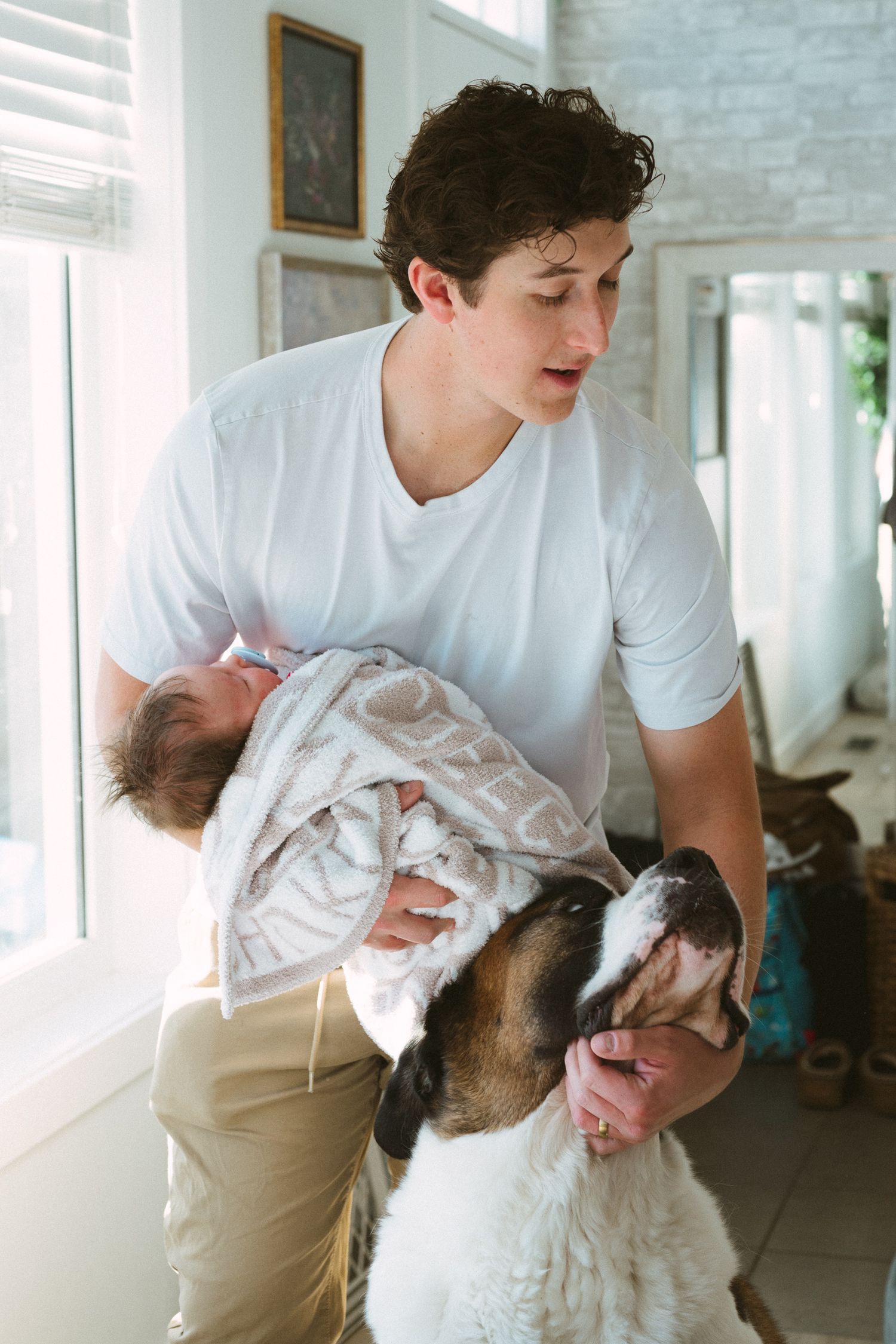 A tender moment between a person in a white shirt and a fluffy dog showing affection and bonding.