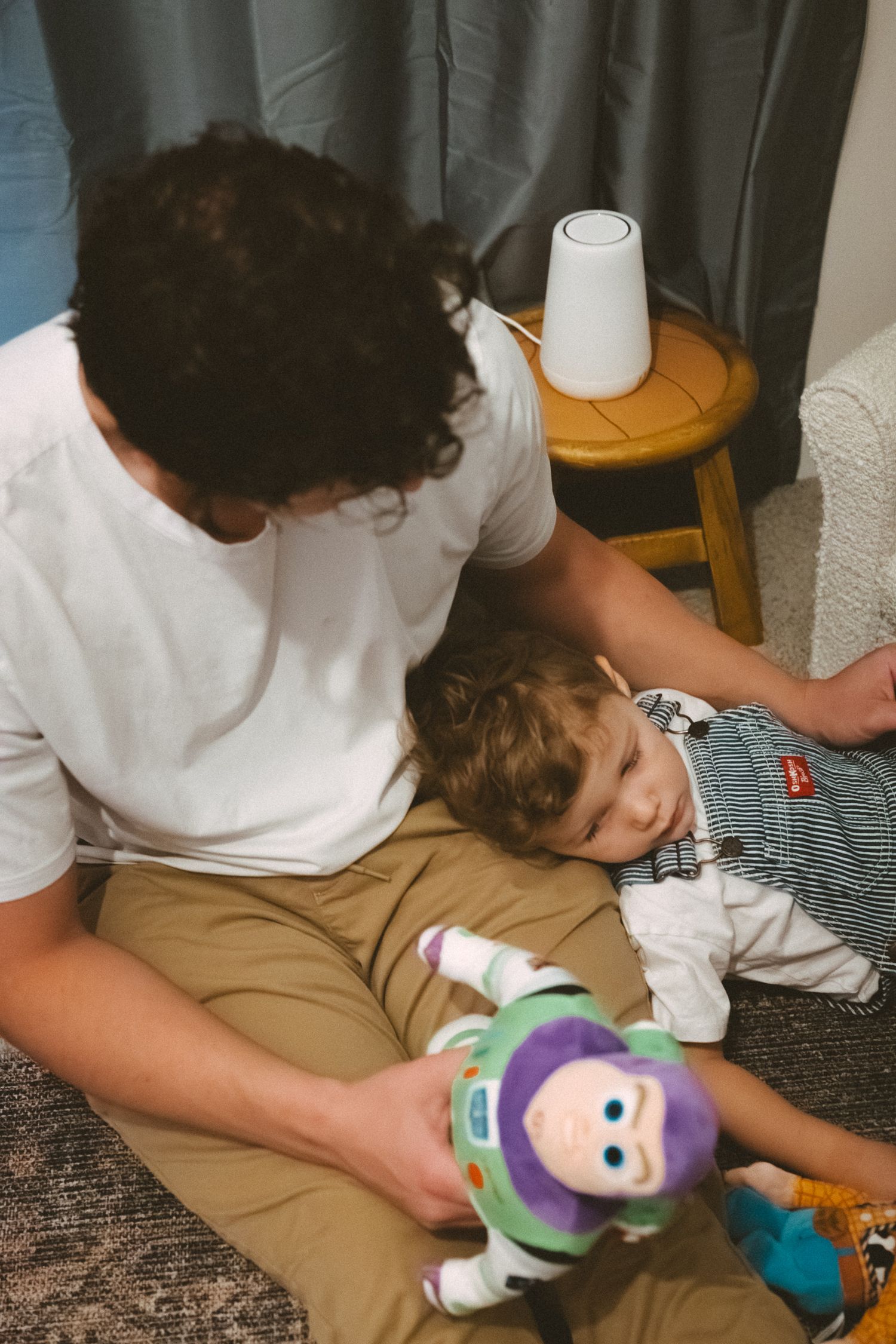 A sequence of photos showing someone playing with a Buzz Lightyear toy while lying on a couch.