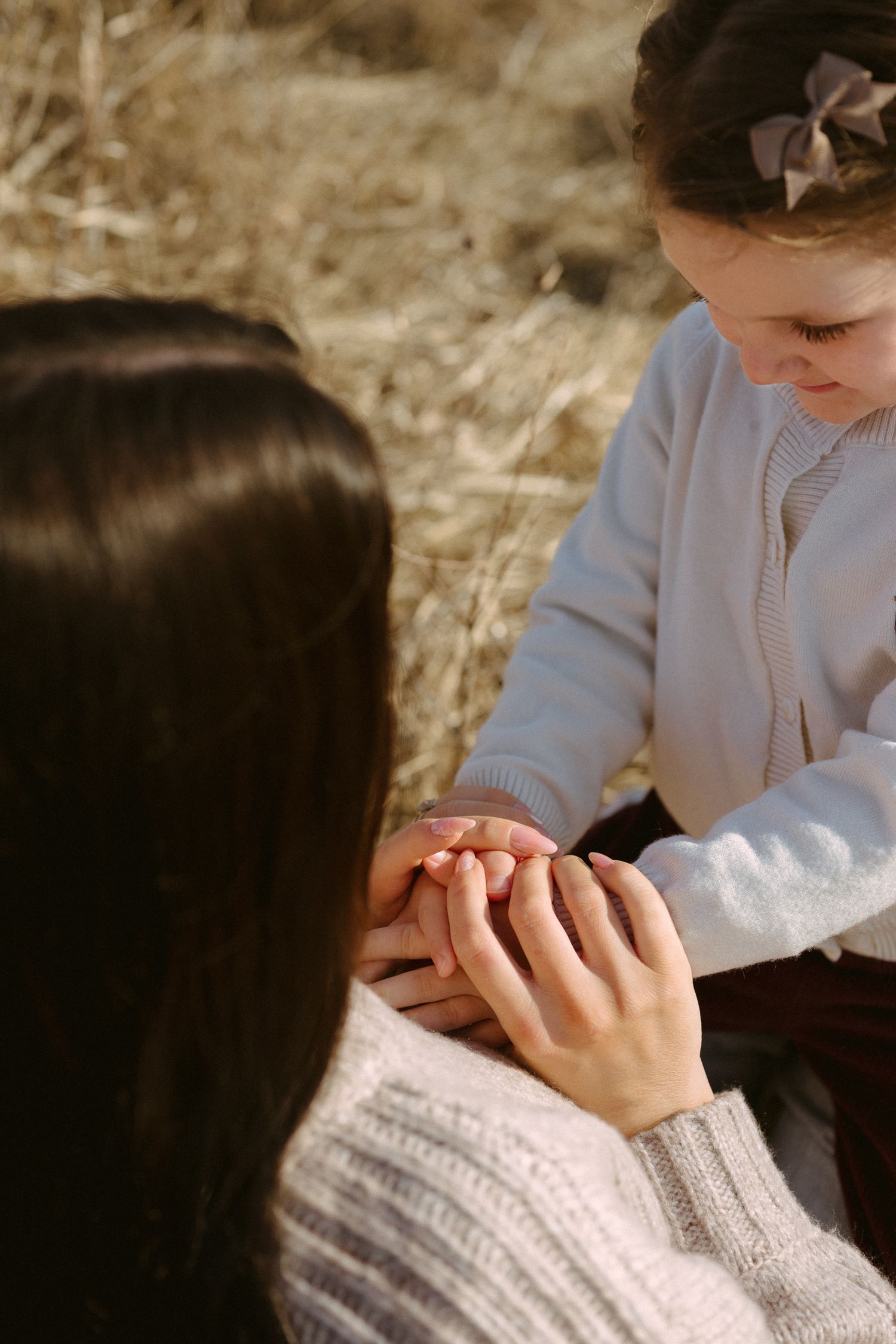 Close-up view of hands clasped together in prayer or contemplation against a soft background.