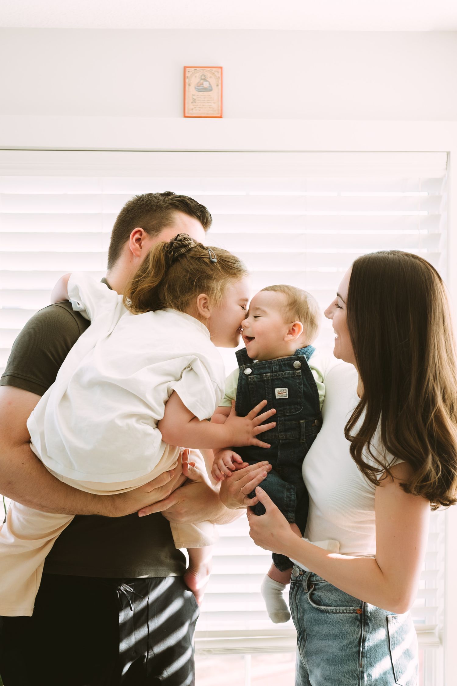Sweet family moment captured in bright indoor setting with natural lighting.