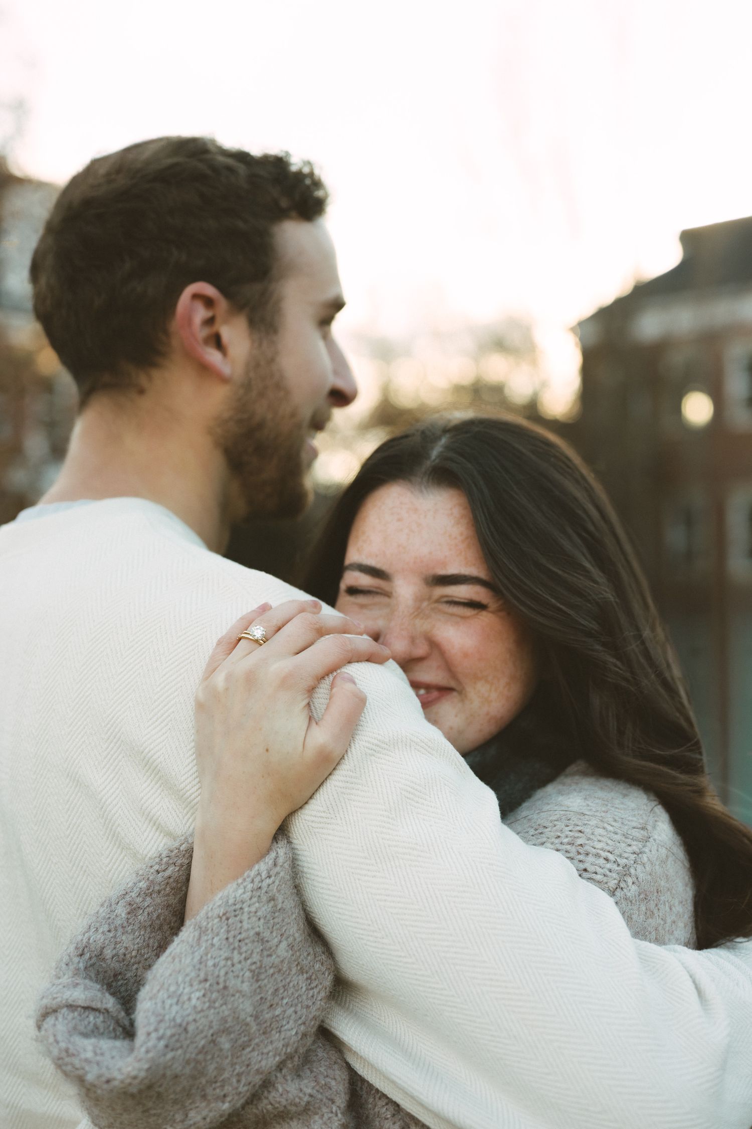 Intimate close-up of a couple embracing and smiling together during a romantic sunset moment.