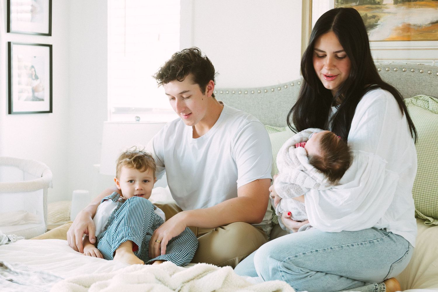 Family sitting together at a table working on homework or reading activities in a bright room.