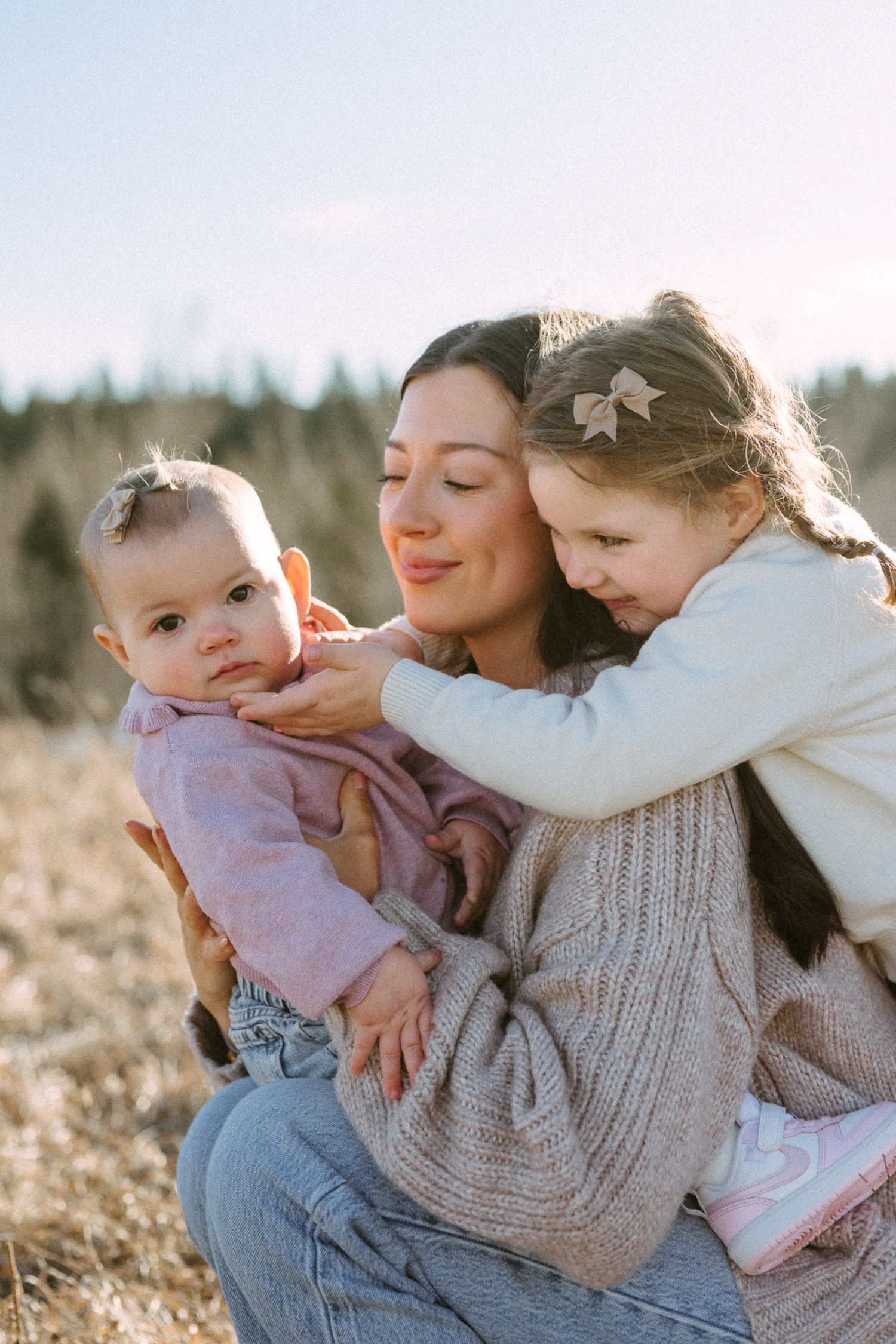 A heartwarming outdoor family portrait with everyone sharing hugs and smiles in natural light.