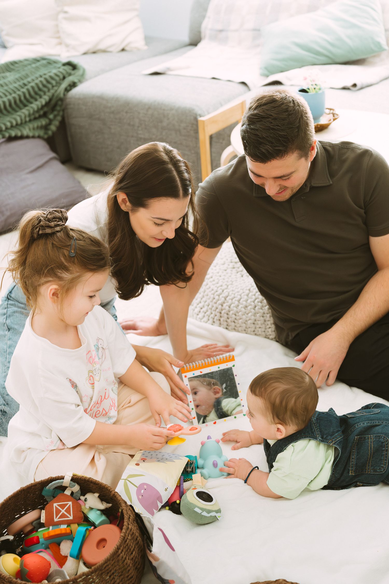 Family enjoying quality time together playing with toys on a cozy bed.