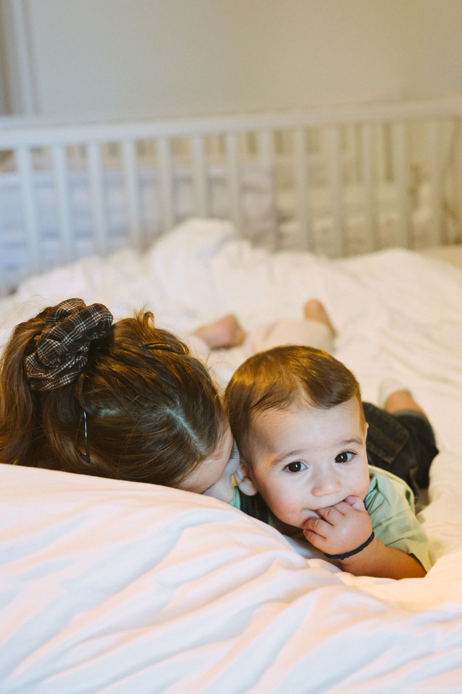 A series of photos showing a baby lying on white bedding in various sleeping positions.