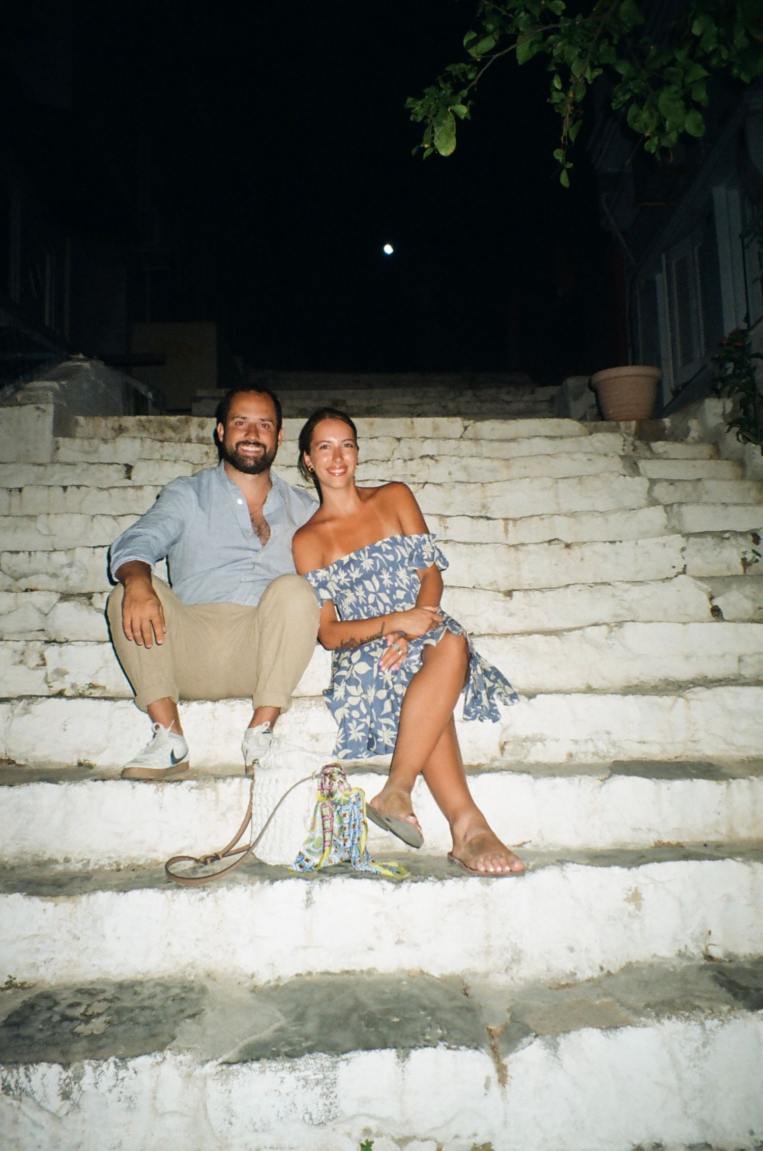 Nighttime gathering on white stone steps with warm lighting.