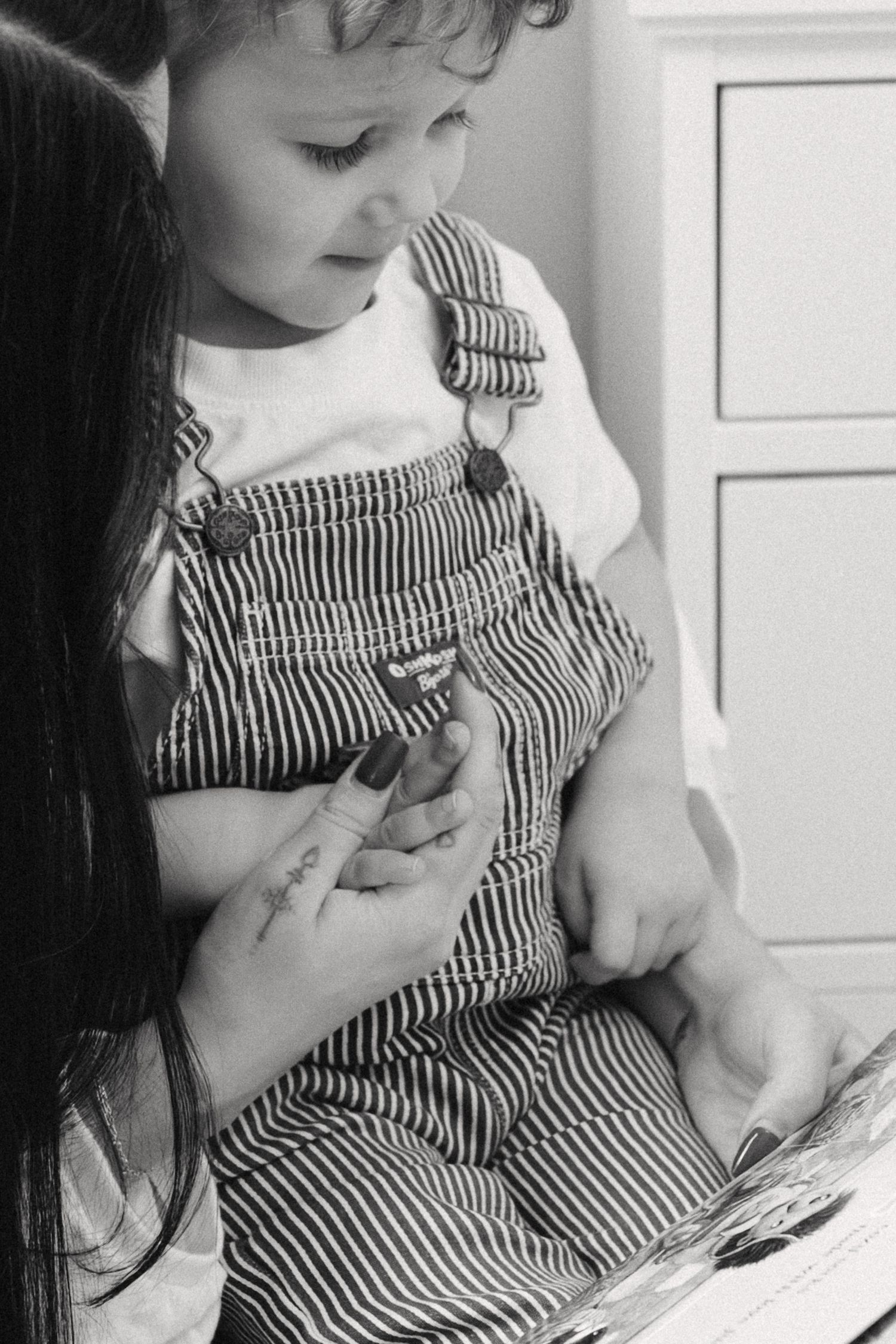 A series of black and white photos showing a small child in striped overalls.