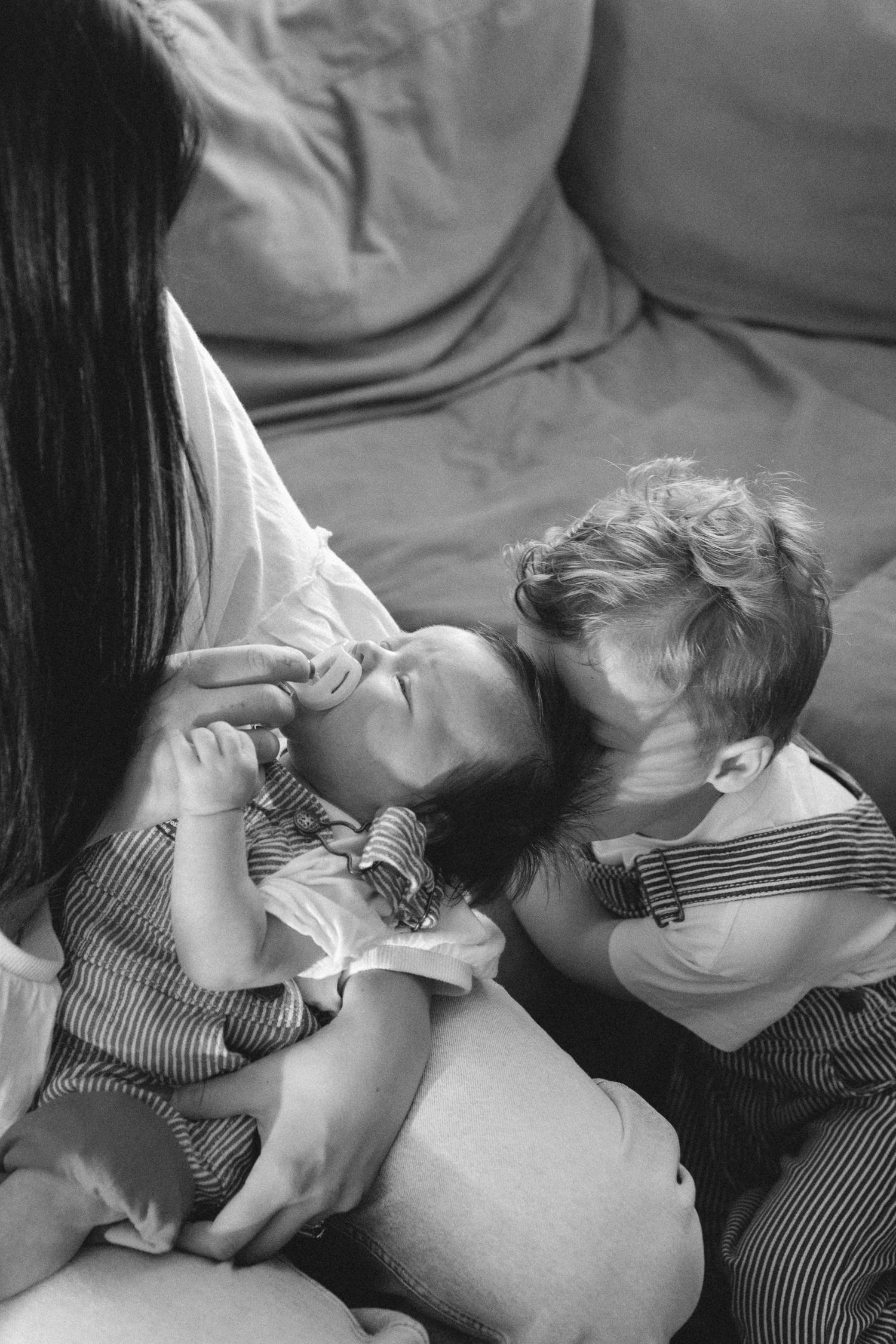 Black and white photo series showing a sleeping infant resting peacefully on a soft surface.