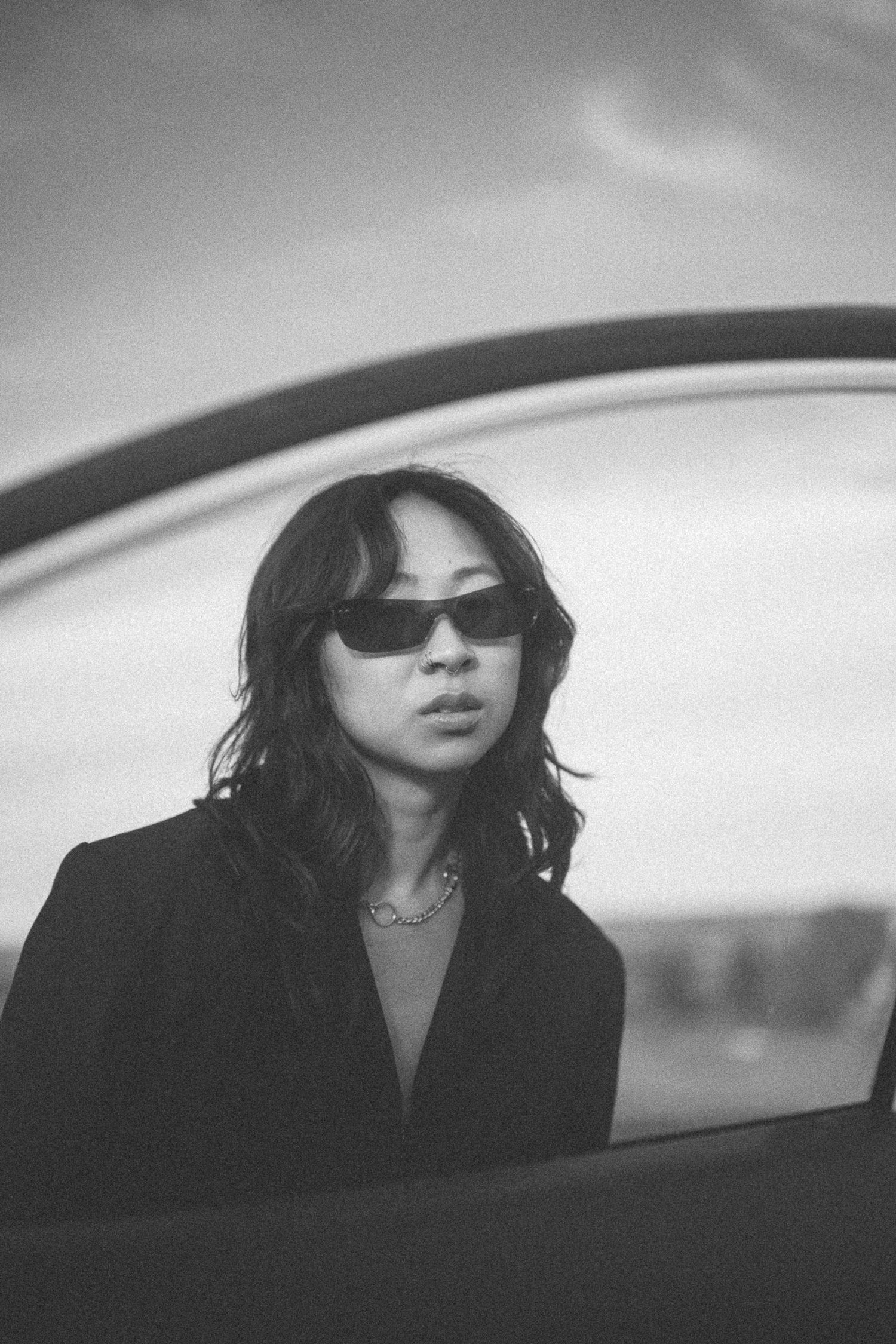Stylish black and white portrait through a car window with sunglasses.