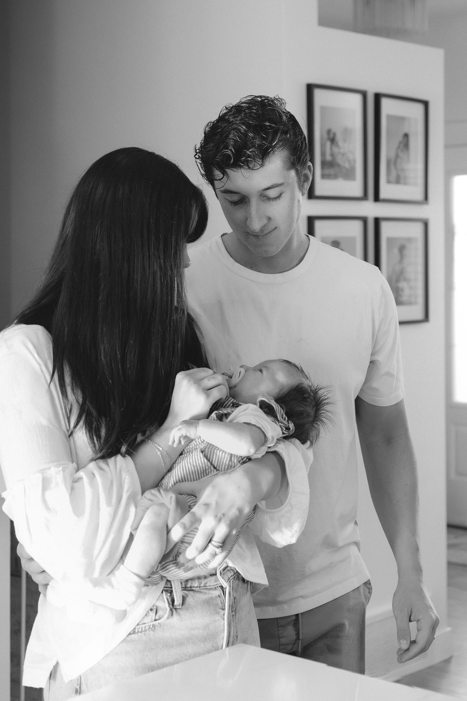 A series of five tender moments showing parents cradling and bonding with their newborn baby at home.