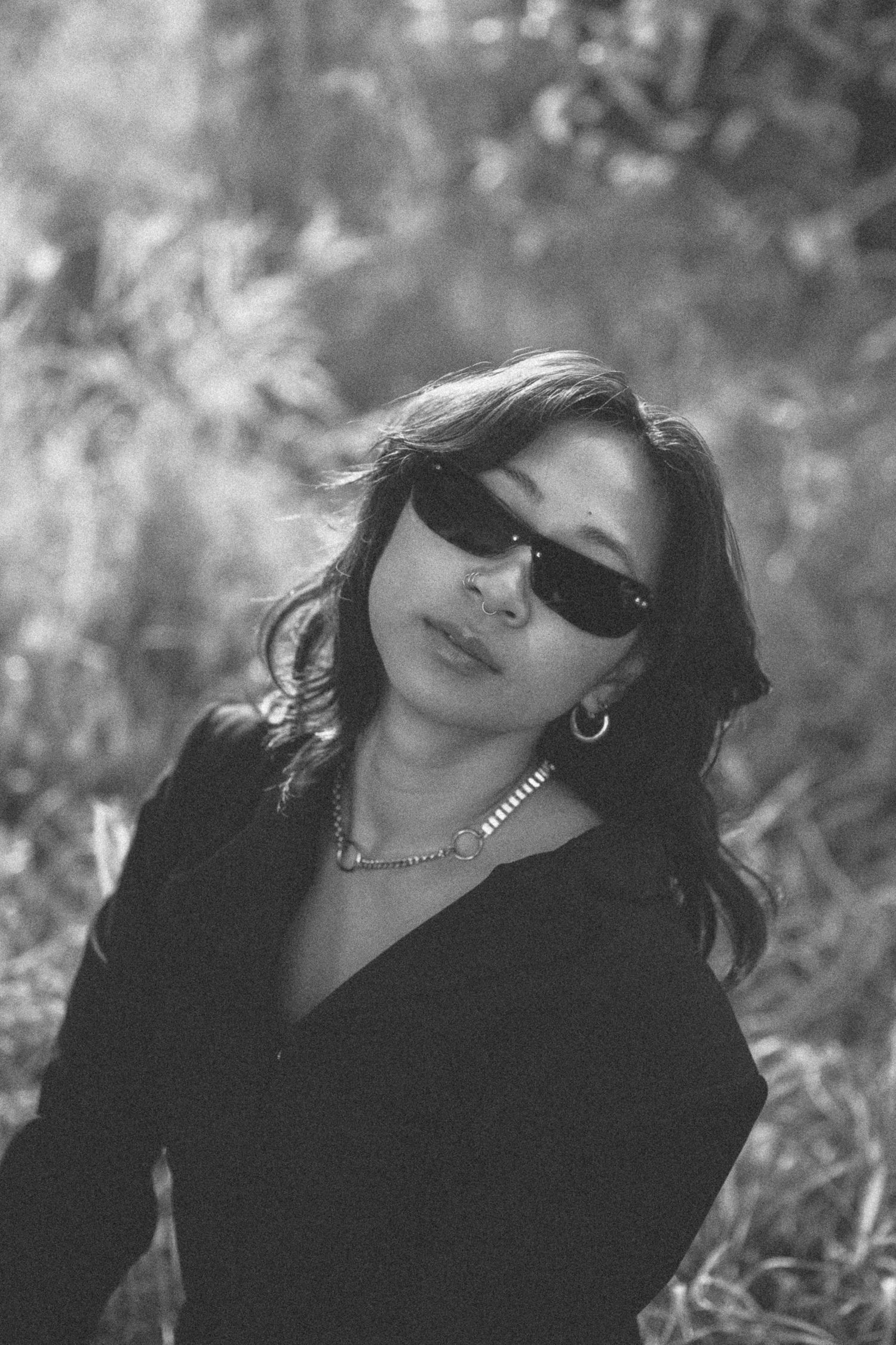 Black and white portrait creates moody atmosphere in outdoor setting.