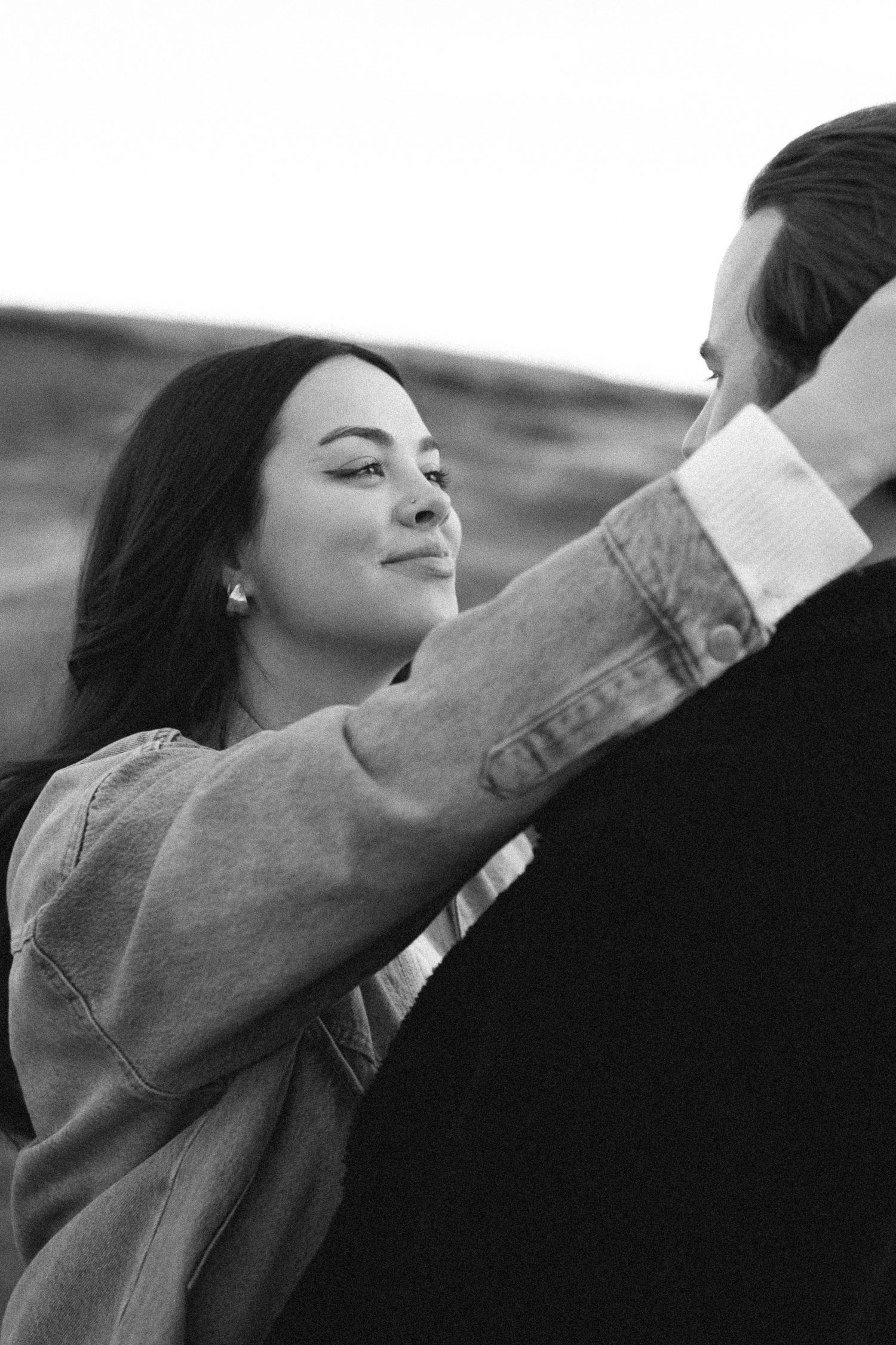 Black and white photo series showing a person in denim jacket stretching their arms in a dance-like motion.