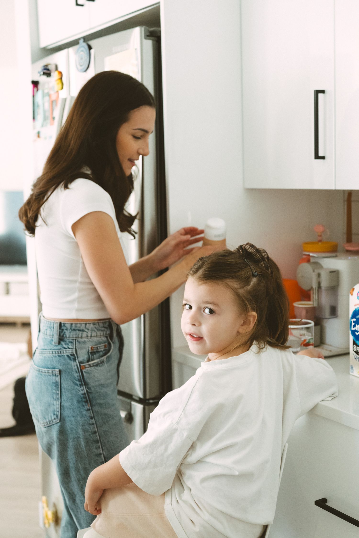 A hair styling session in a bright modern kitchen.