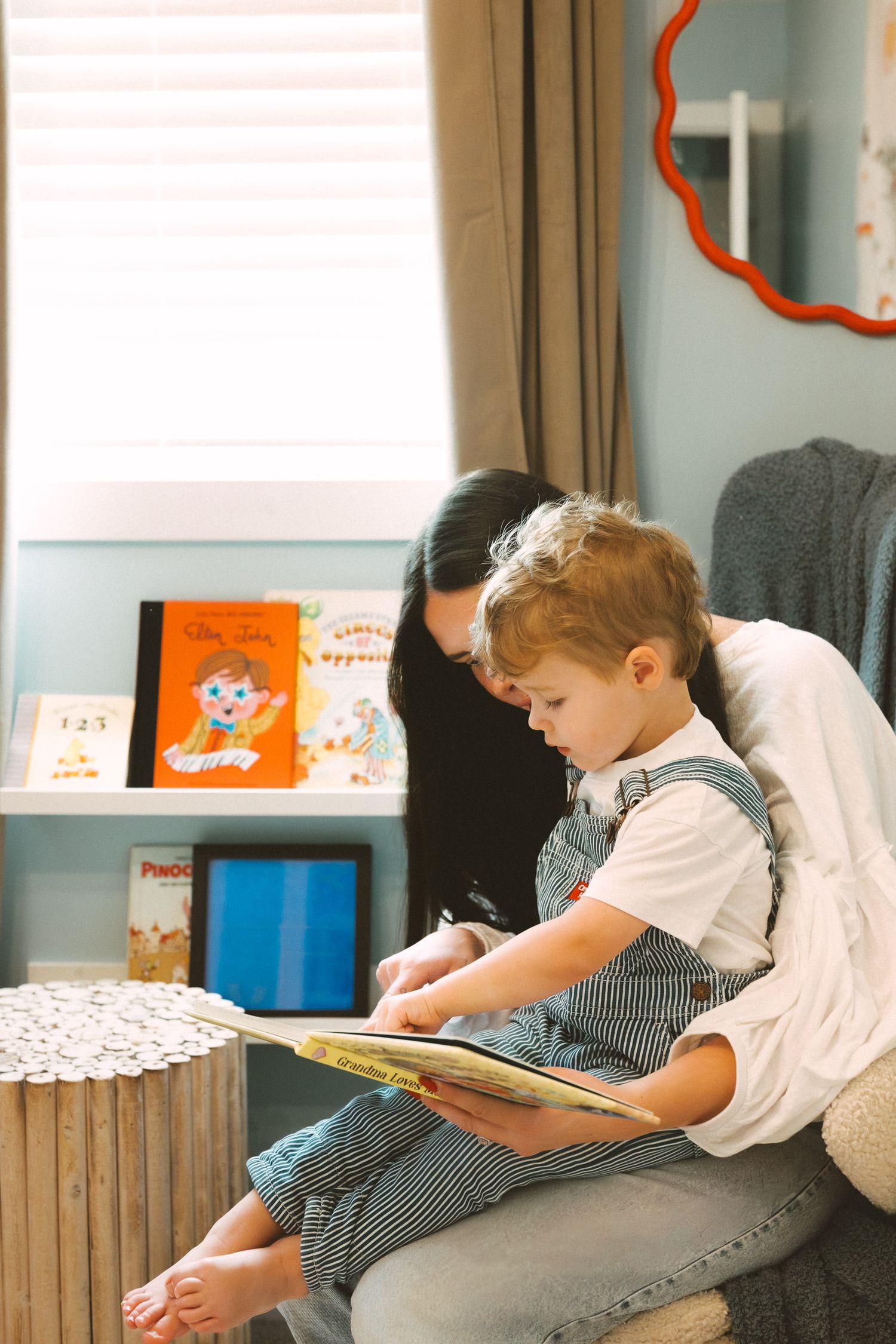 A child in a gingham dress sits on a couch reading a book in a series of progressive poses.