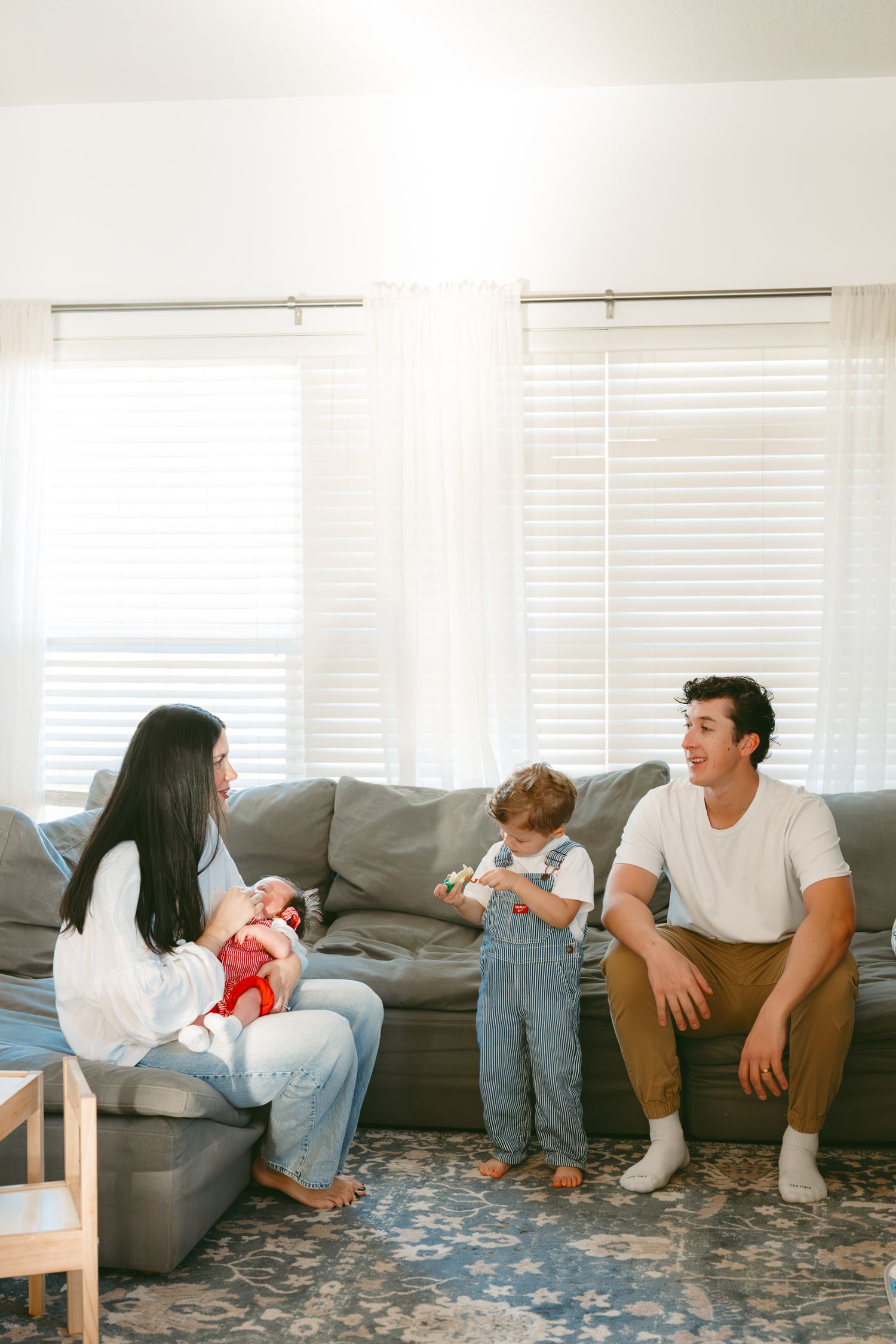 A series of candid photos showing people relaxing and chatting while sitting on the floor next to a gray couch.