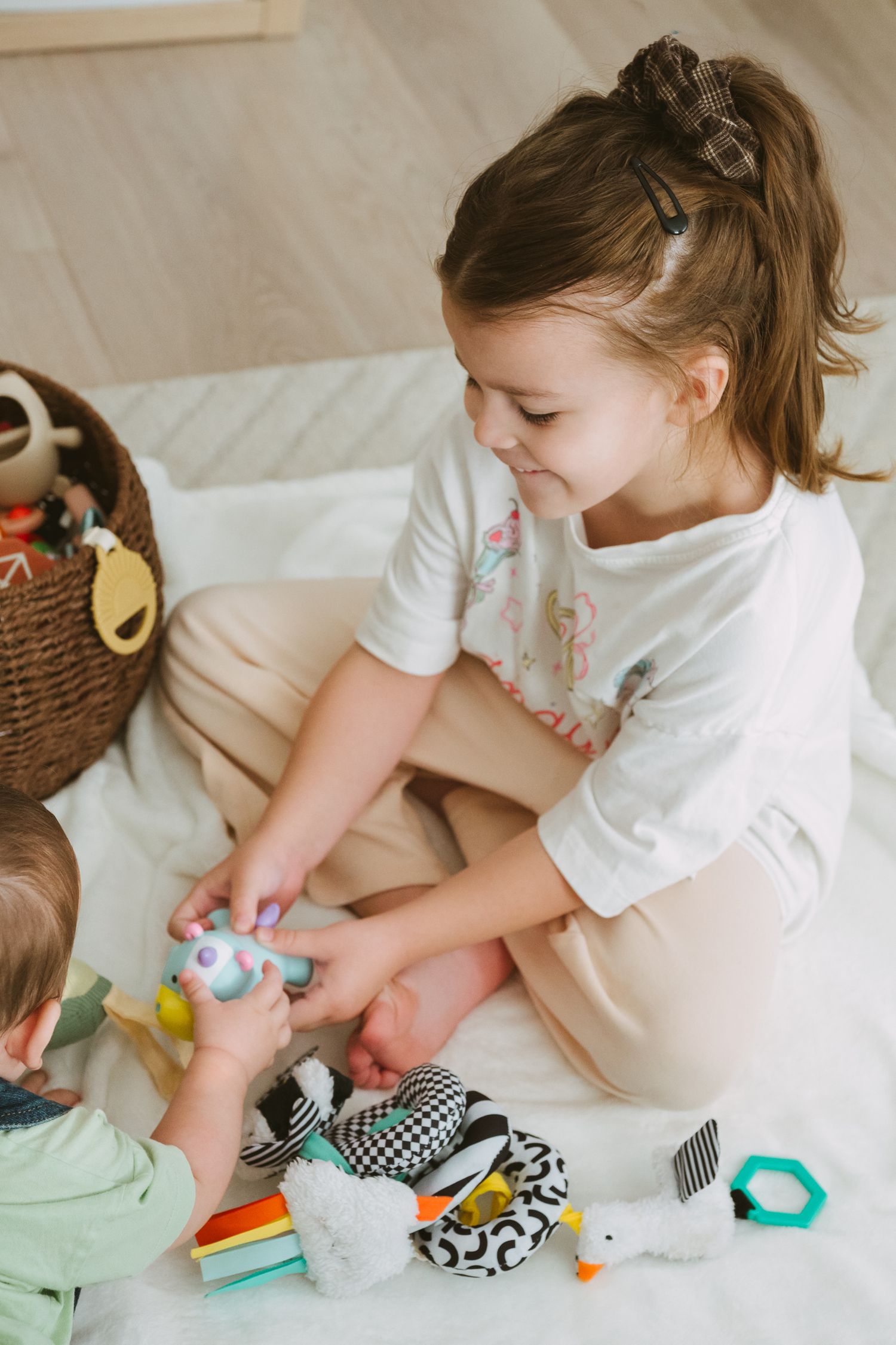 Child sorting and organizing toys and items on a white surface.