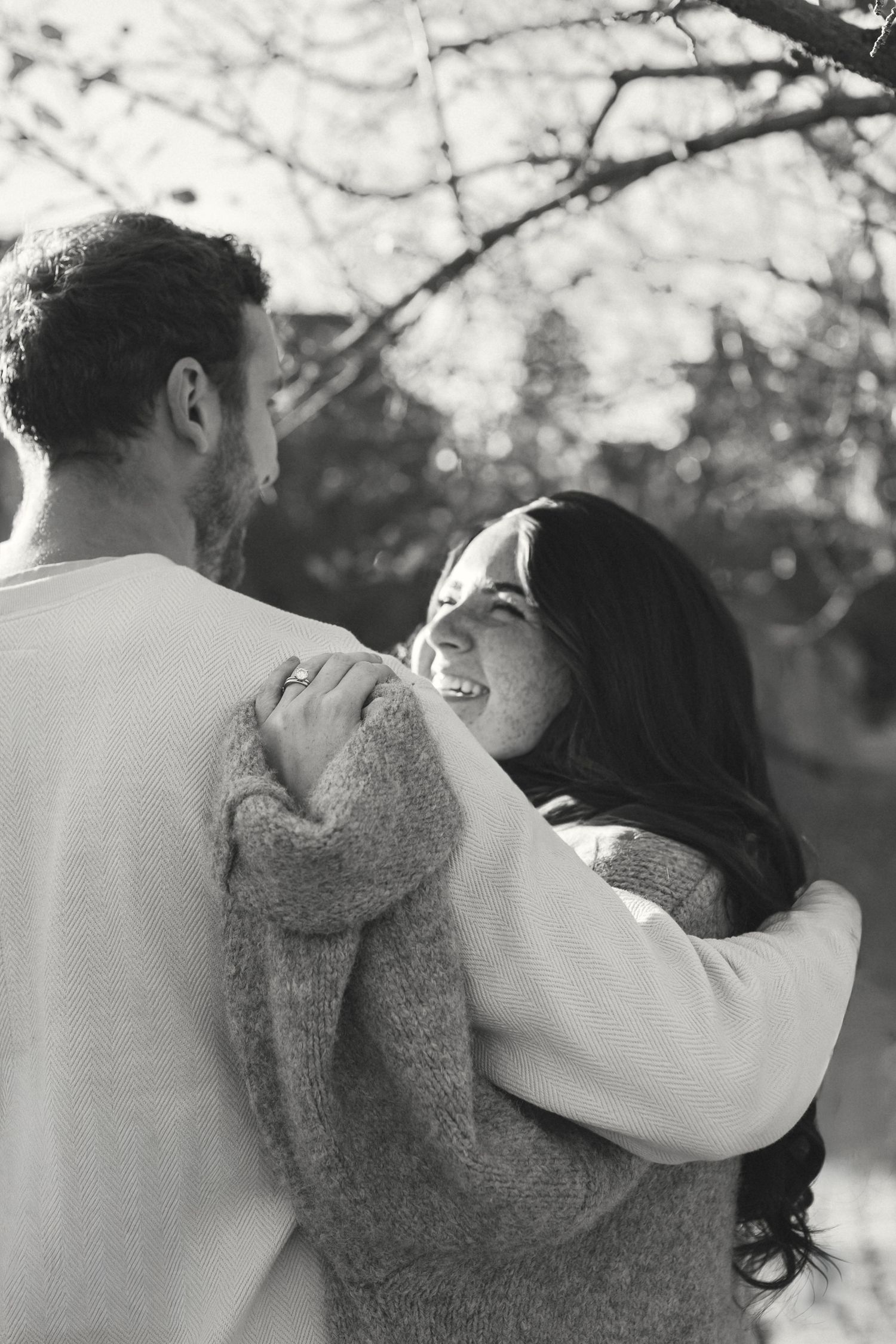 Romantic couple embracing in a tender moment outdoors during golden hour.