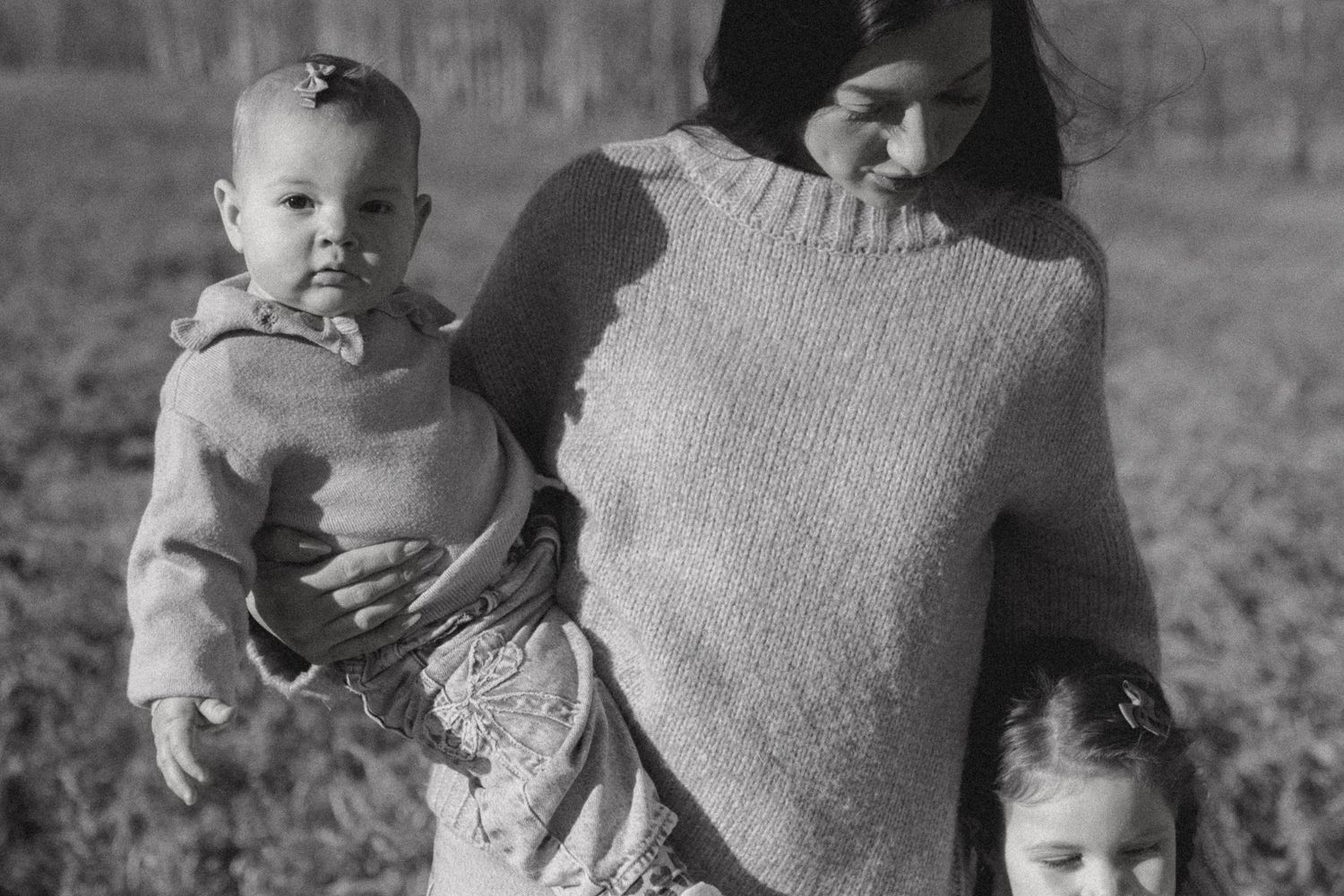 A series of black and white vintage photographs showing people holding babies outdoors.