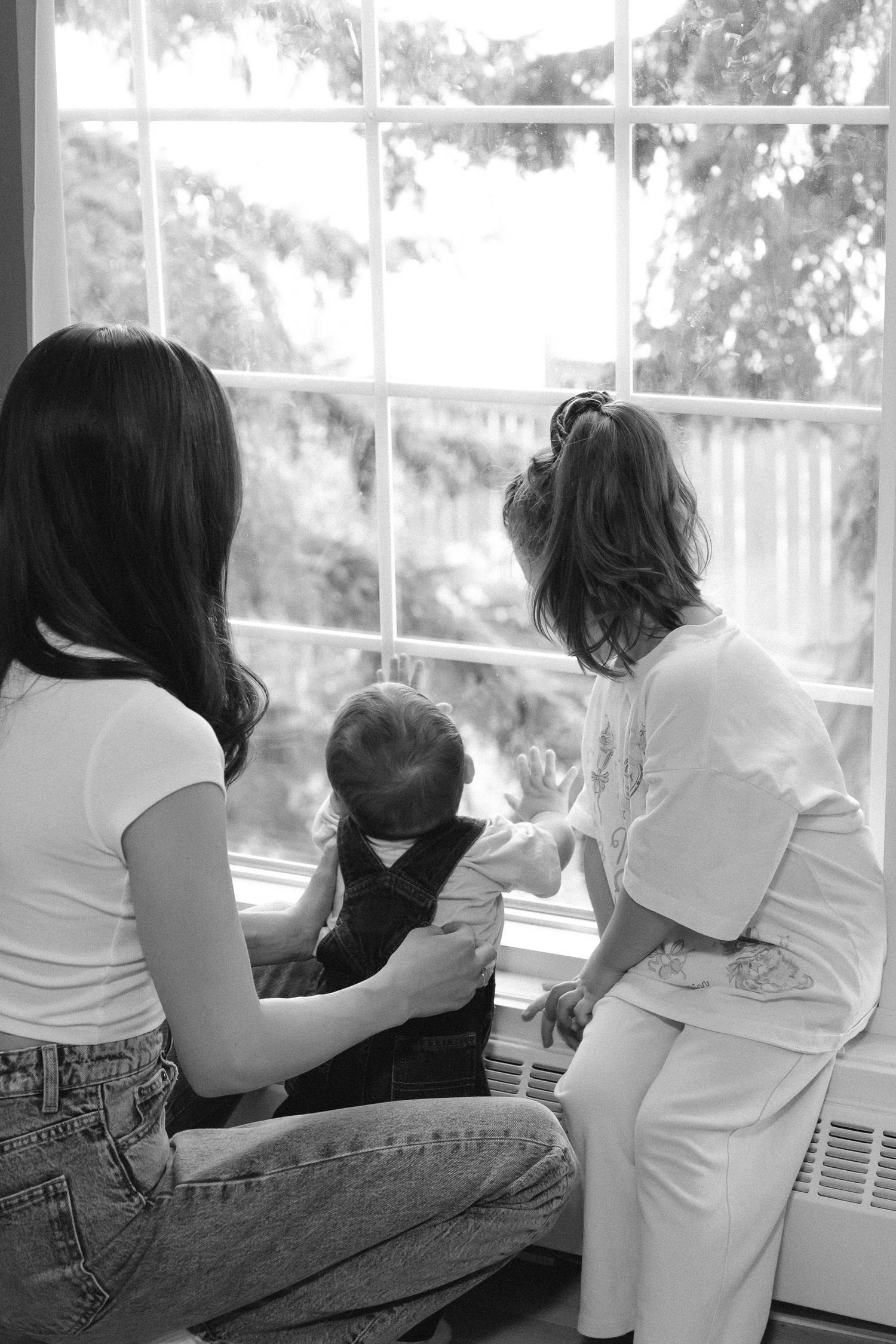 A sequence of black and white photos showing people sitting by a window looking outward.
