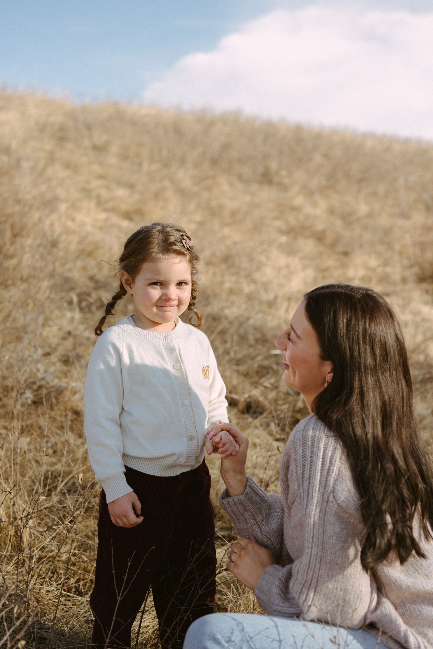 Candid photos showing playful interaction between parent and child in an outdoor field setting.