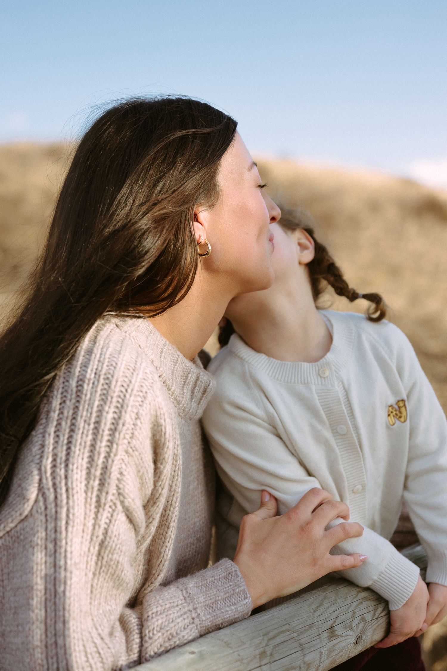 A series of intimate photos showing two people in cozy sweaters sharing tender moments together.