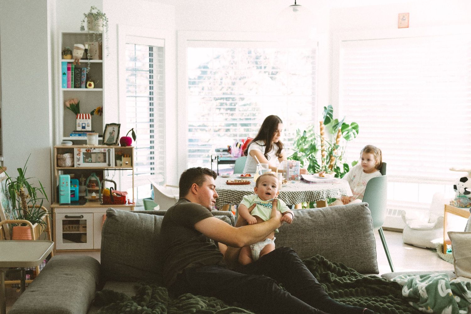 A collection of four interior photos showing a modern living room with white furniture and natural lighting.