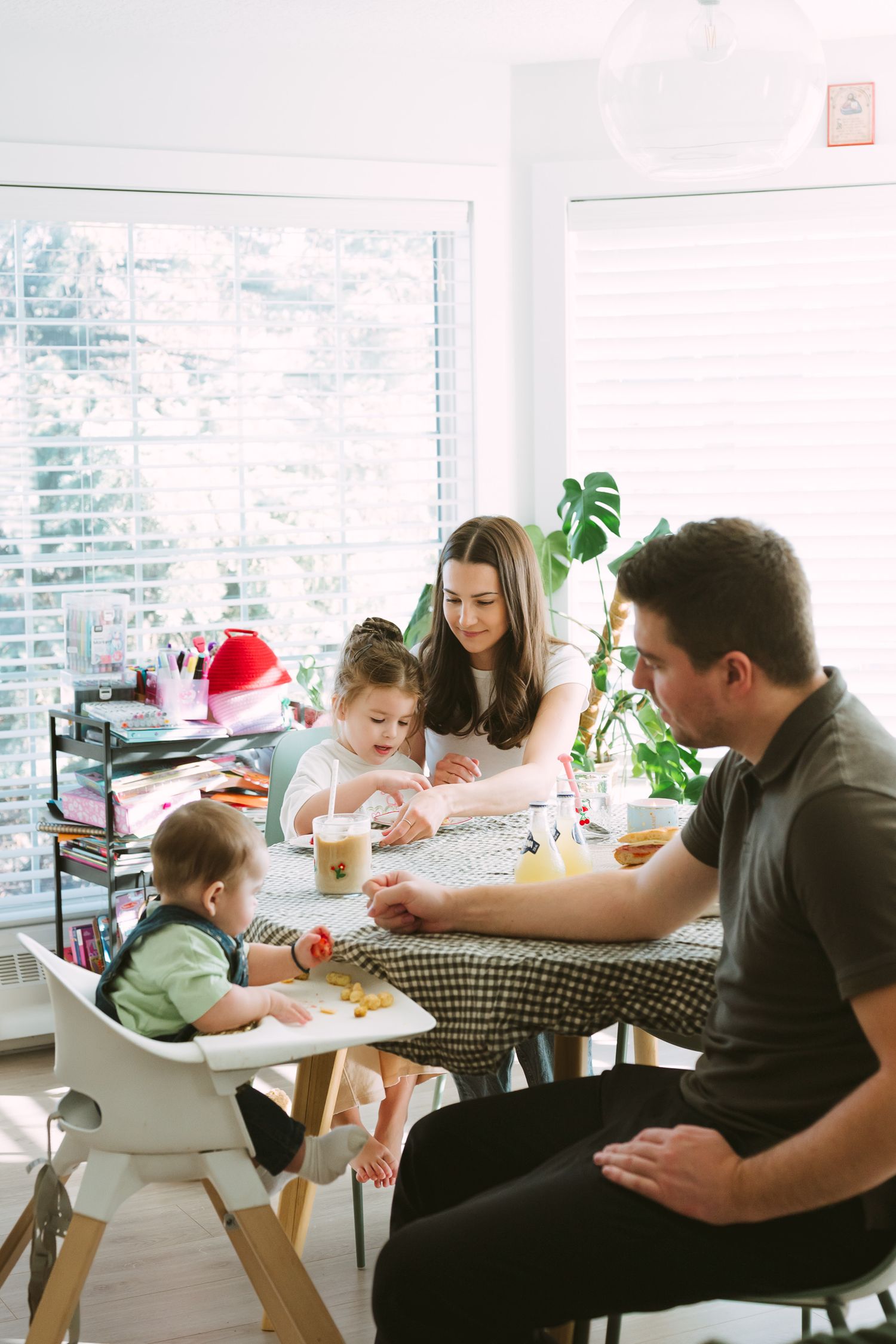 Family gathered around a table enjoying a meal together in a bright modern dining space.
