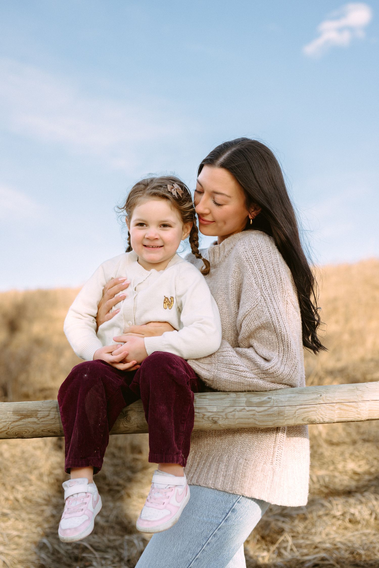 A heartwarming outdoor scene of a parent and child sharing tender moments on a wooden bench against a natural backdrop.