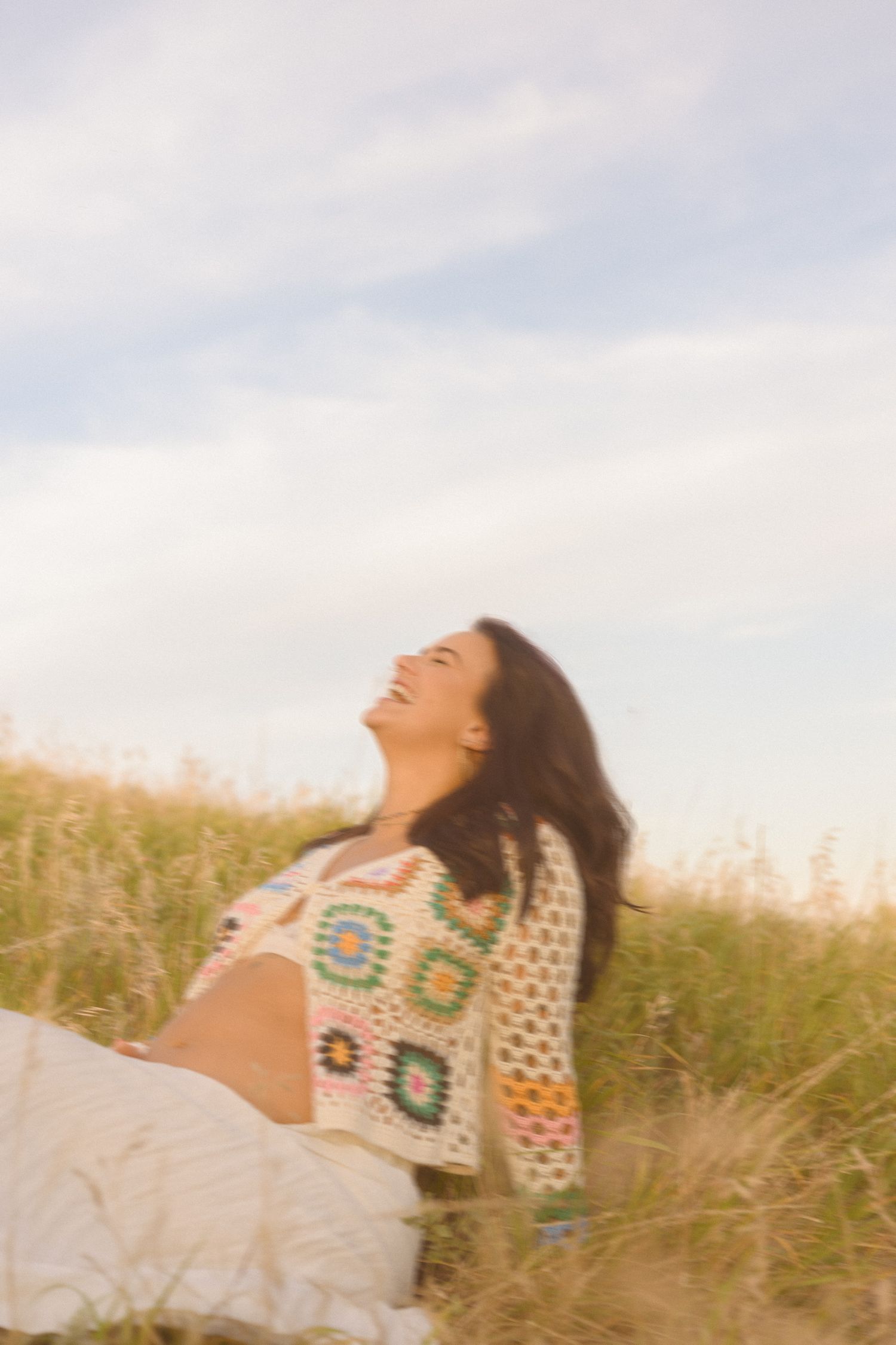 Joyful outdoor portrait session in a meadow during golden hour.